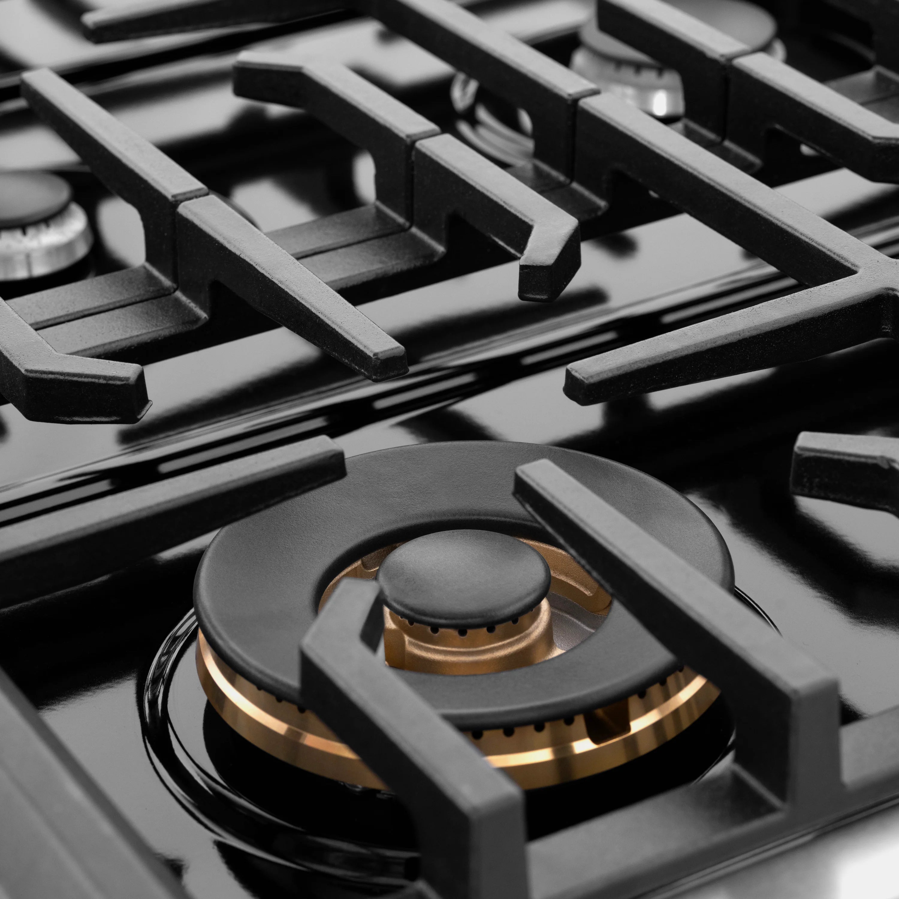 Stainless steel gas cooktop with five black grates and center burner knob