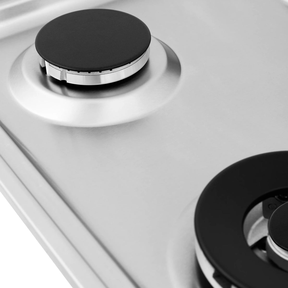 Black burner cap on a white gas cooktop surface with visible metal control knobs