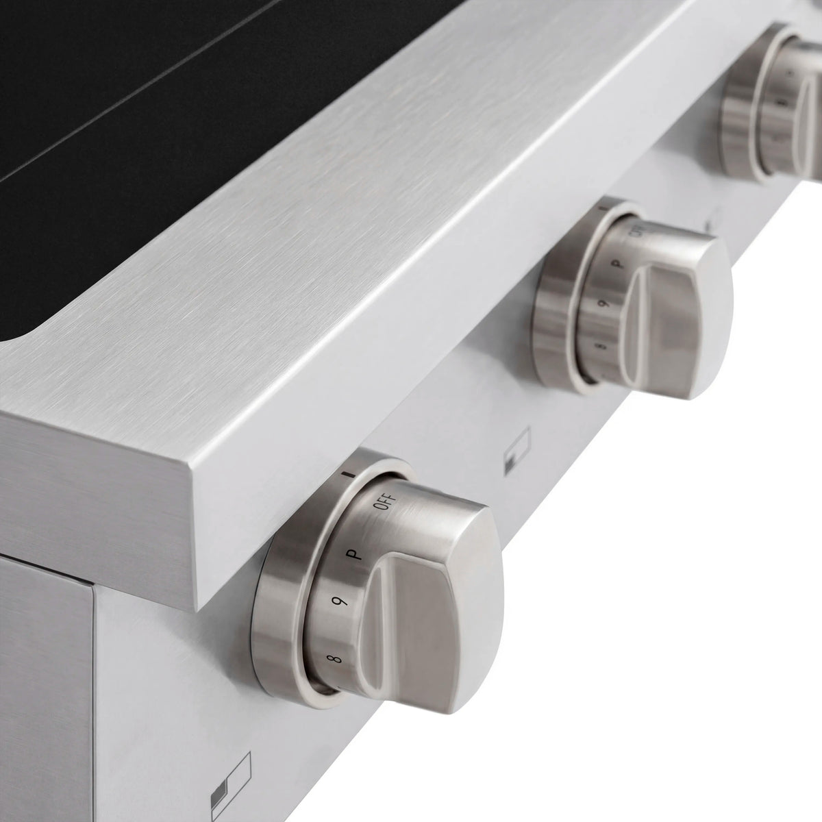 Stainless induction cooktop knob on black glass panel with printed heat levels