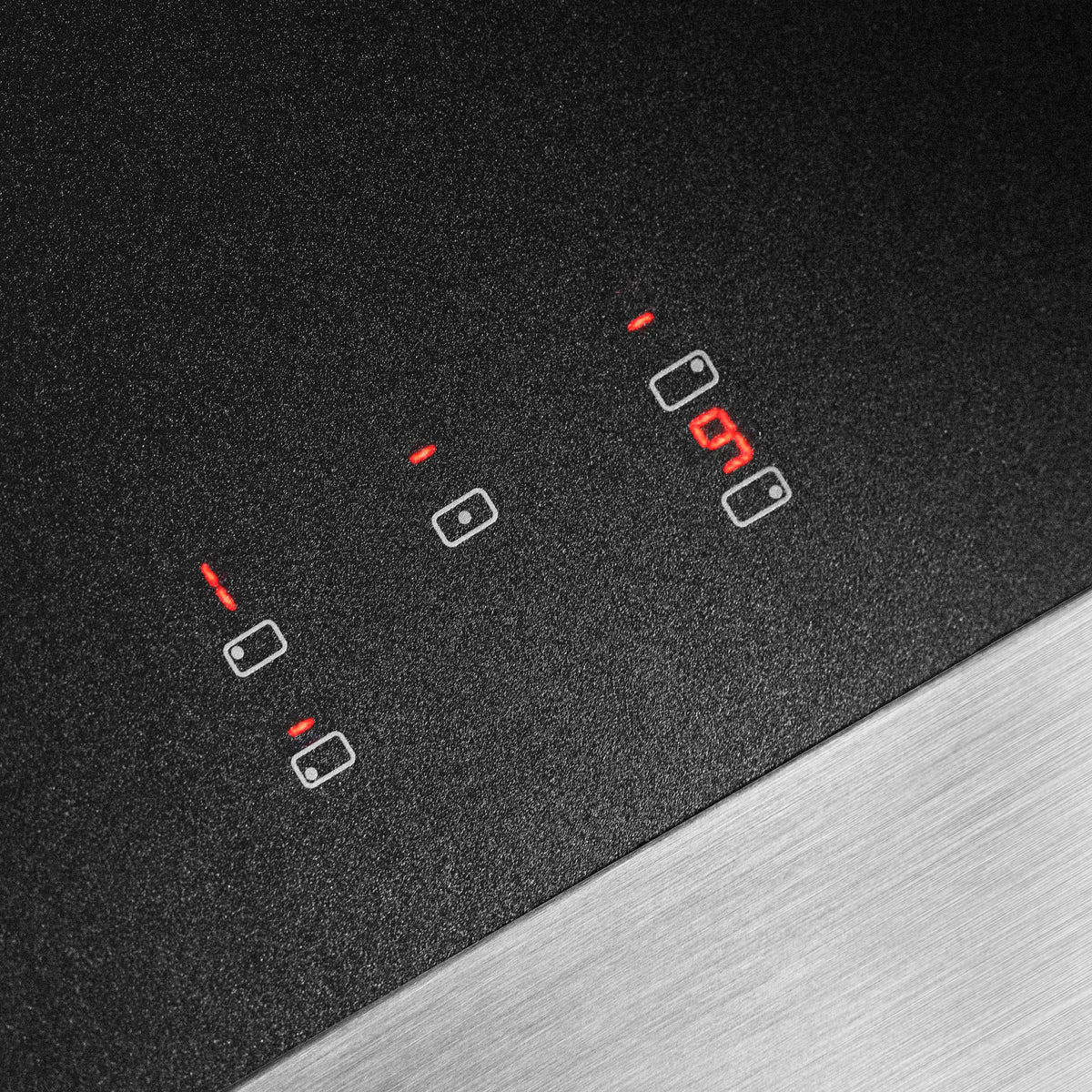 Induction cooktop glass with heating zone indicators glowing red