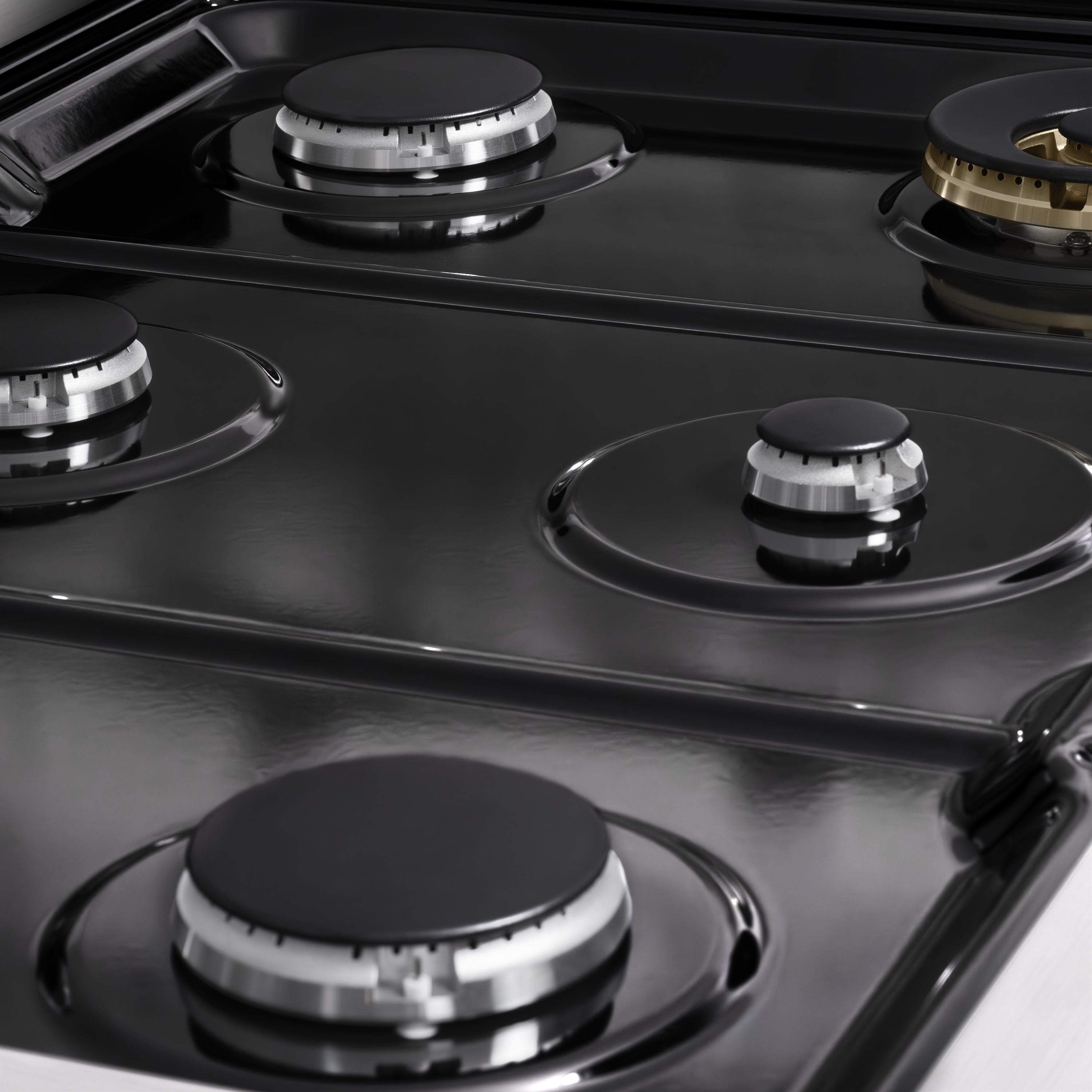 Glass cooktop with four gas burner grates and black control knobs
