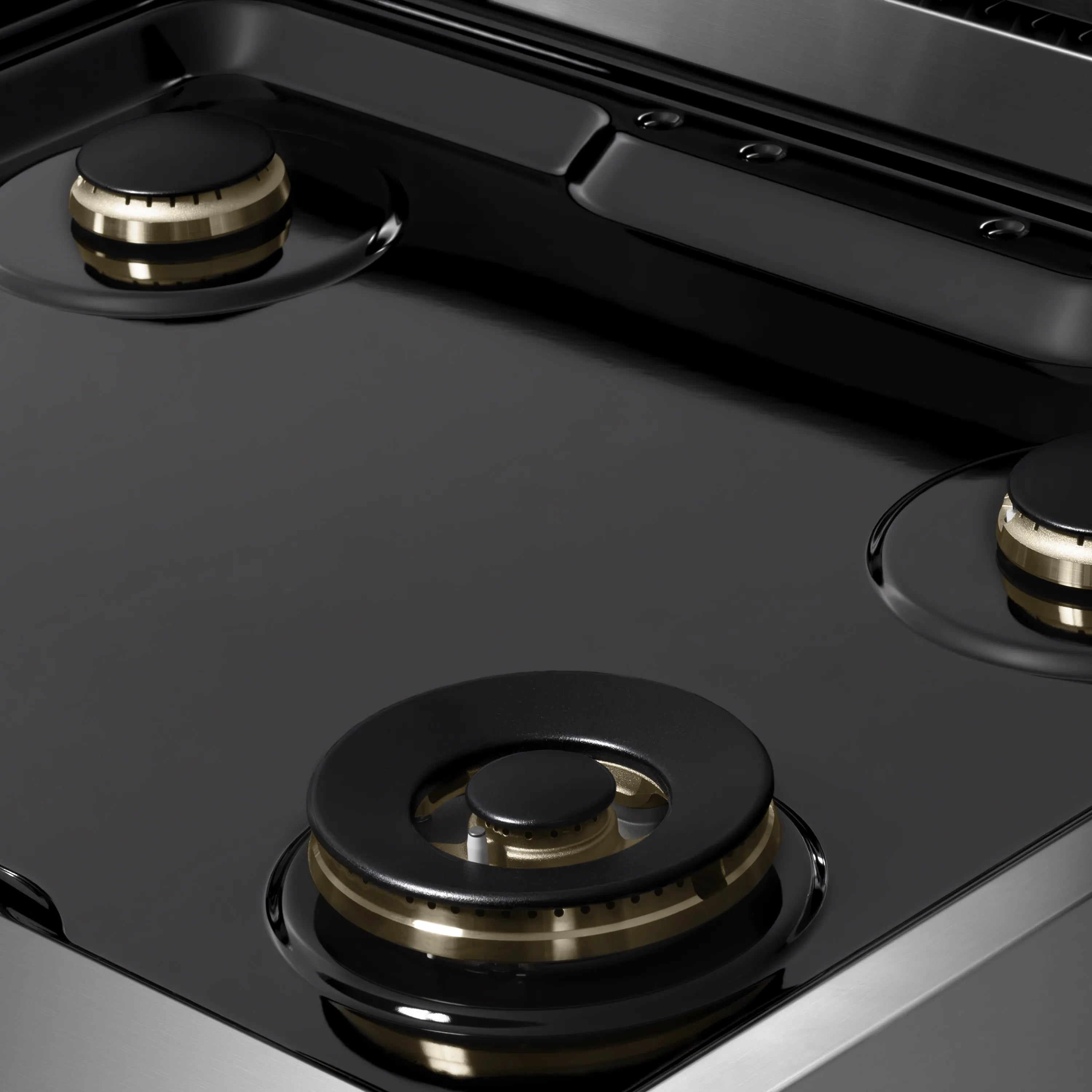 Black cooktop with two gas burners and brass-ring bases on stainless steel range