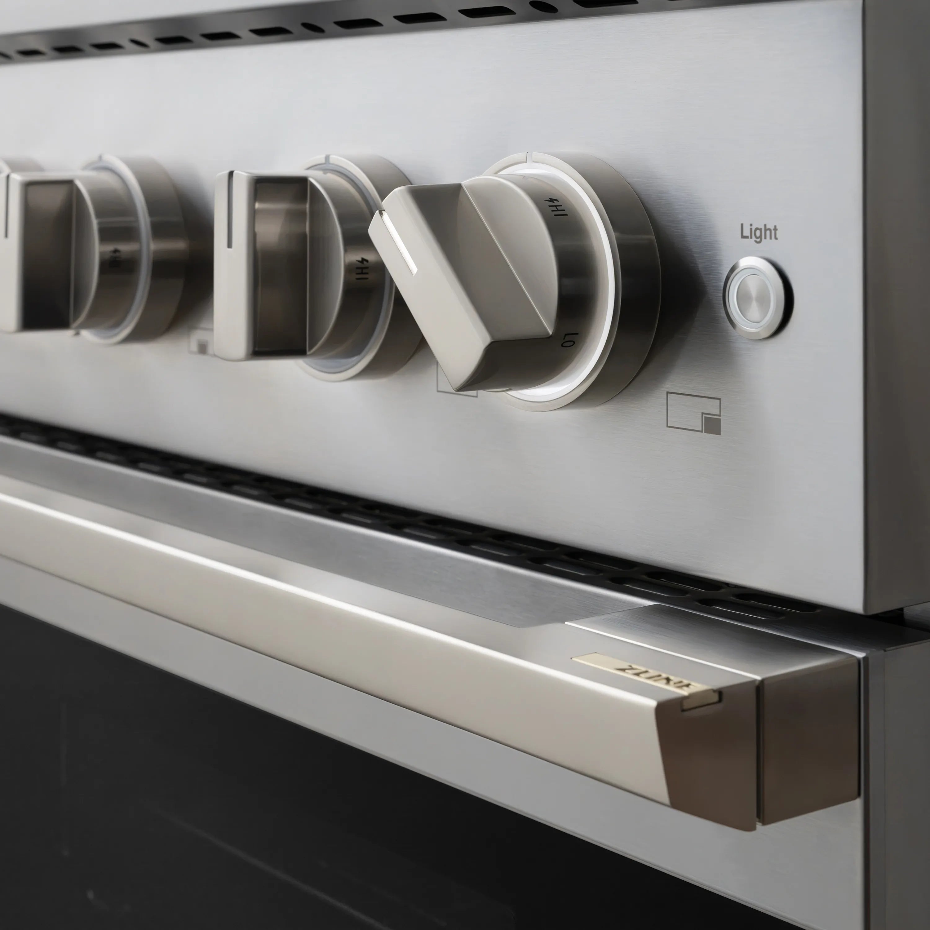 Stainless oven control panel with “Light” knob and temperature/setting dial markings