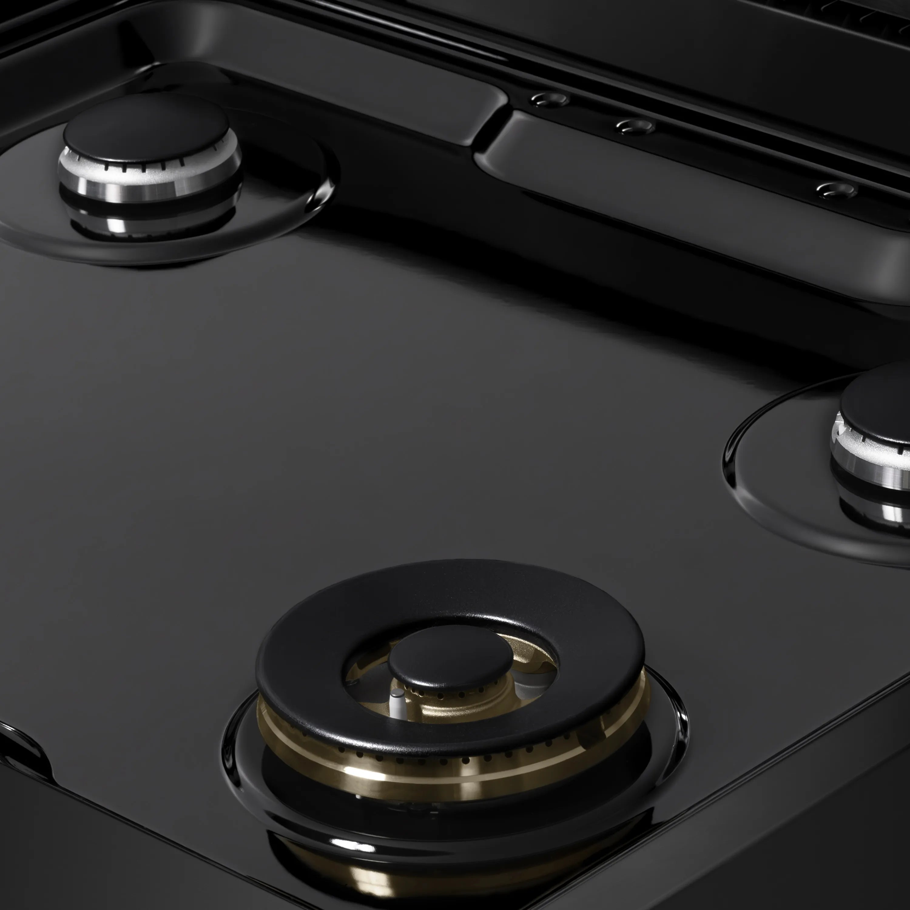 Black gas range cooktop burner with round black cap and brass ring