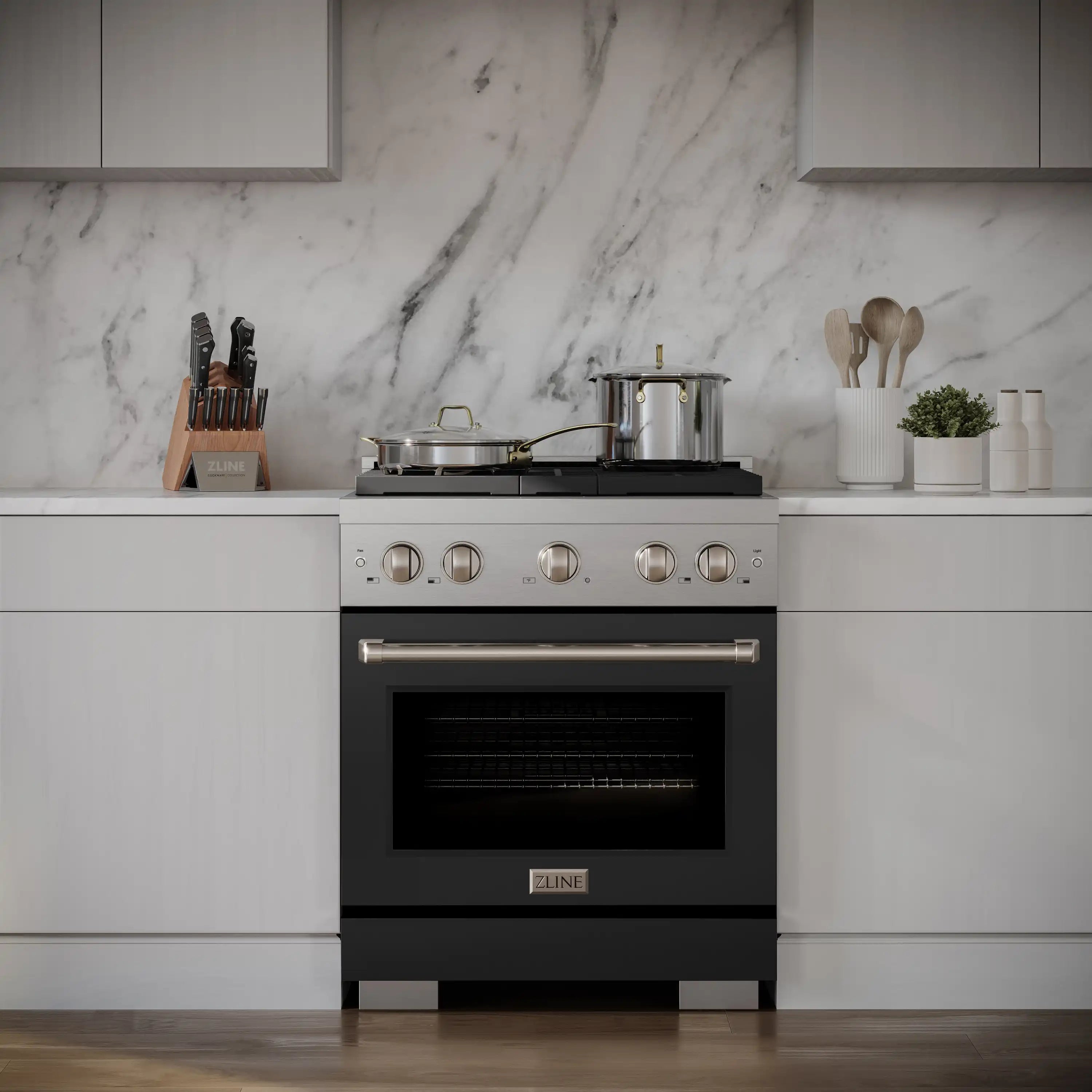 Stainless dual fuel range in kitchen with black matte oven door and four burners