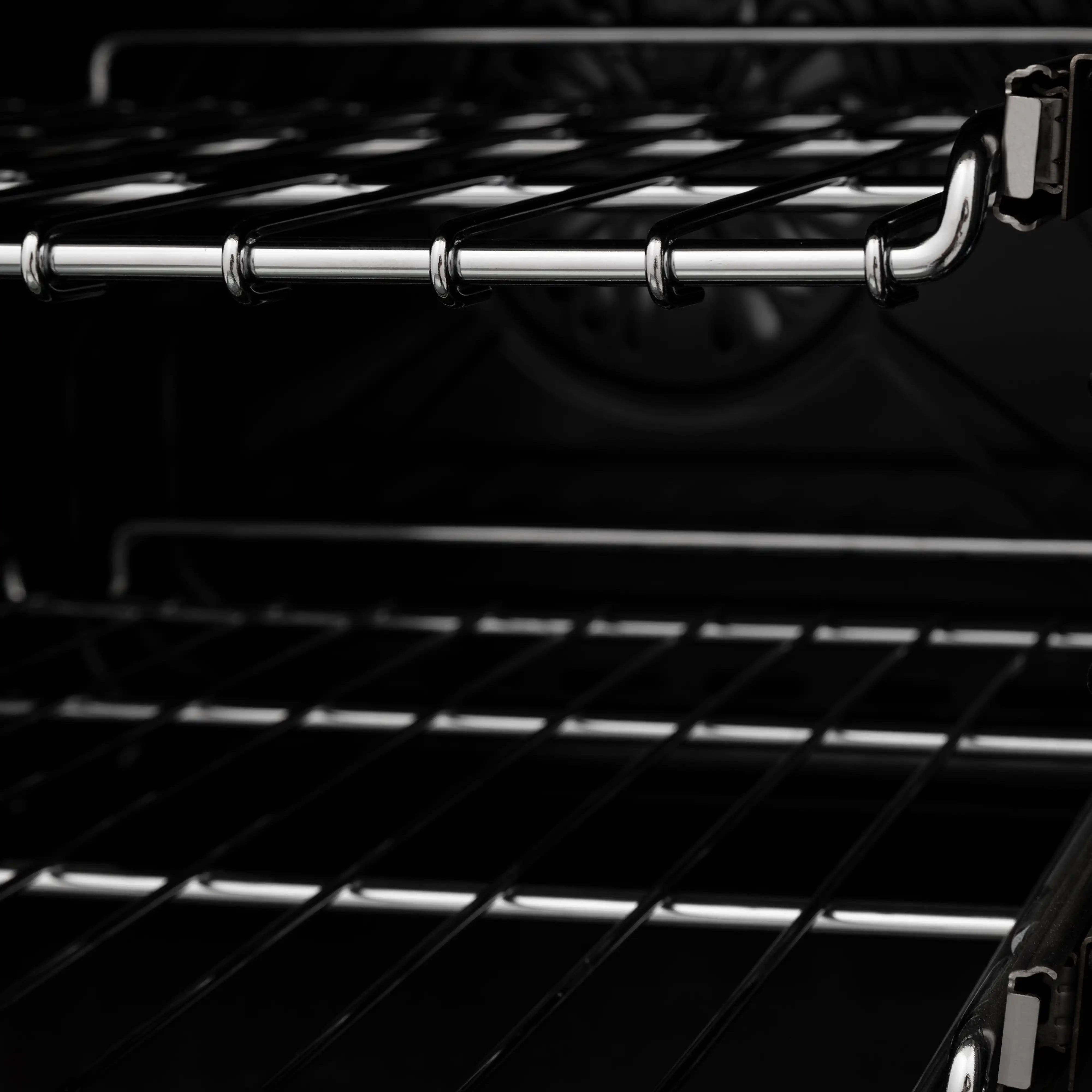 Chrome oven rack supports inside black oven cavity