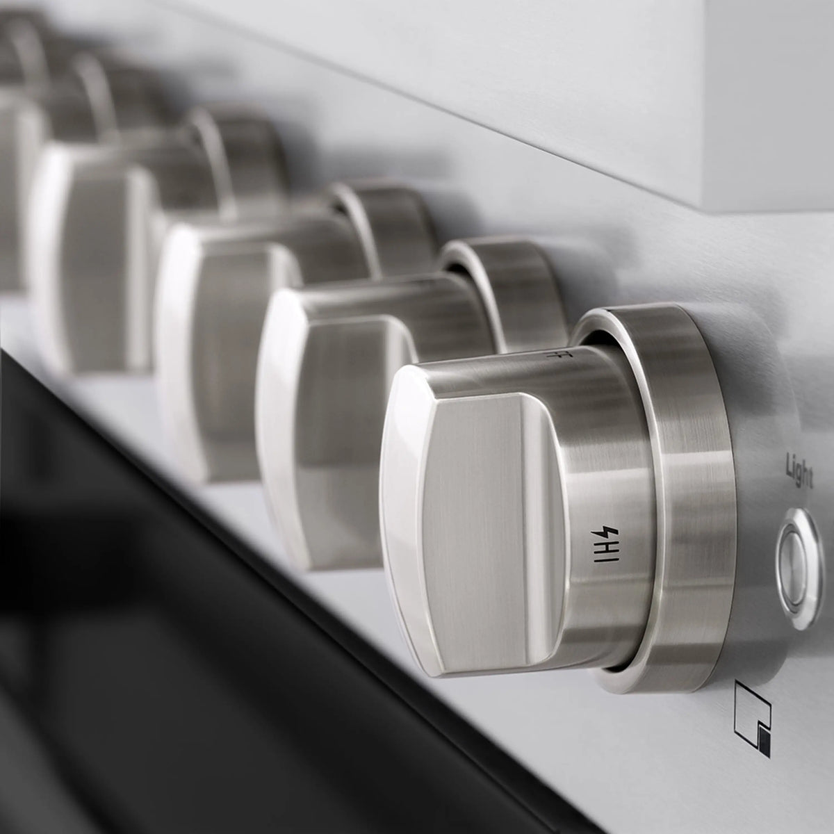 Stainless control knobs on dual fuel range cooktop panel