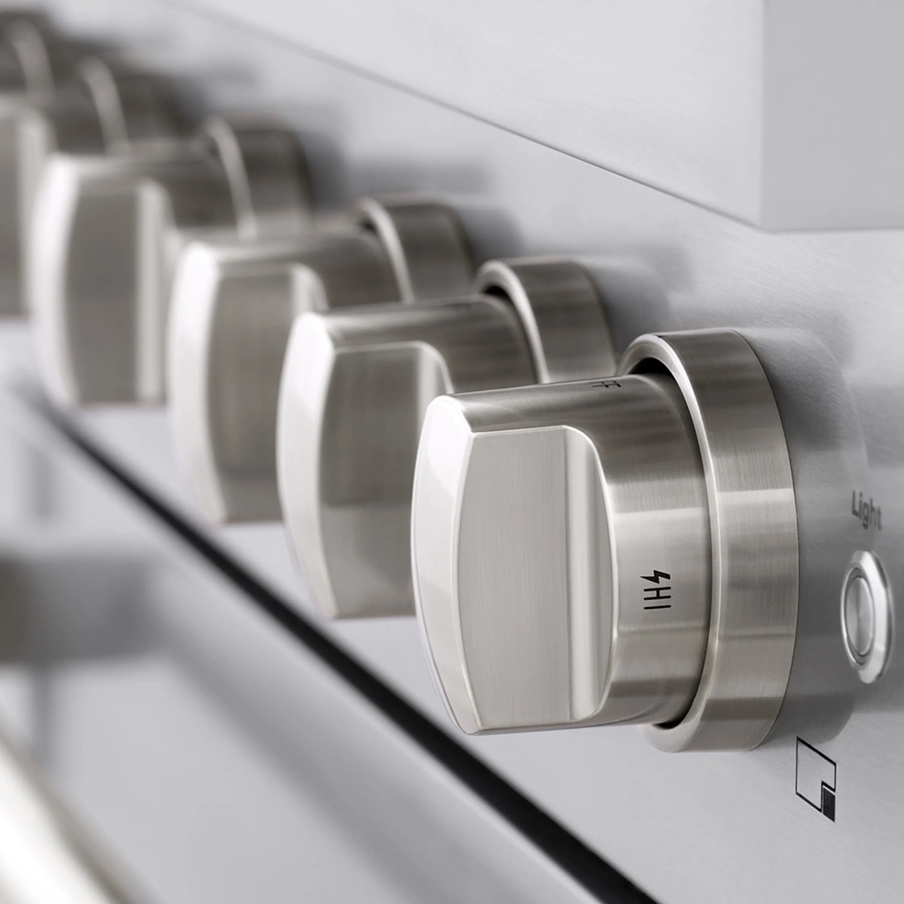 Stainless steel range control knobs along the cooktop