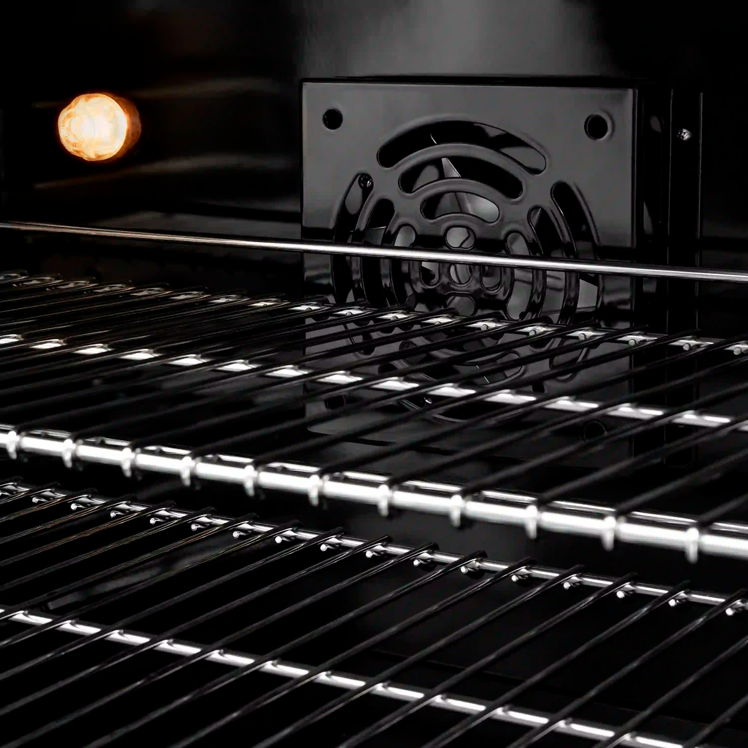 Black grates over an illuminated dual fuel burner with stainless cooktop surface