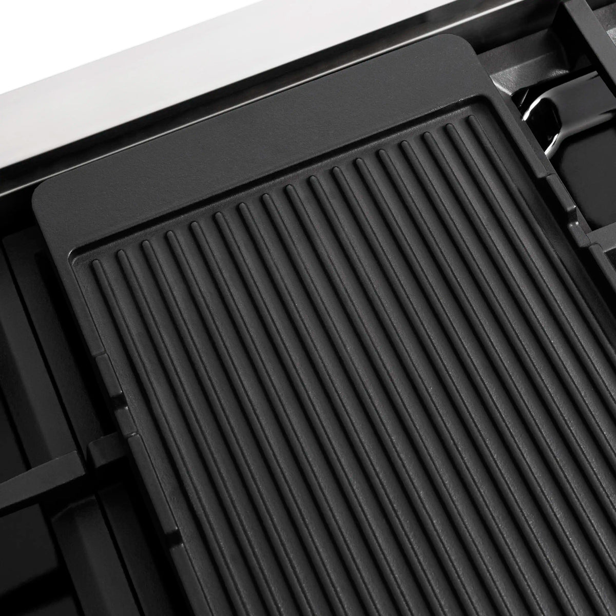 Dual fuel range cooktop burner area with ridged black insert and metal grates