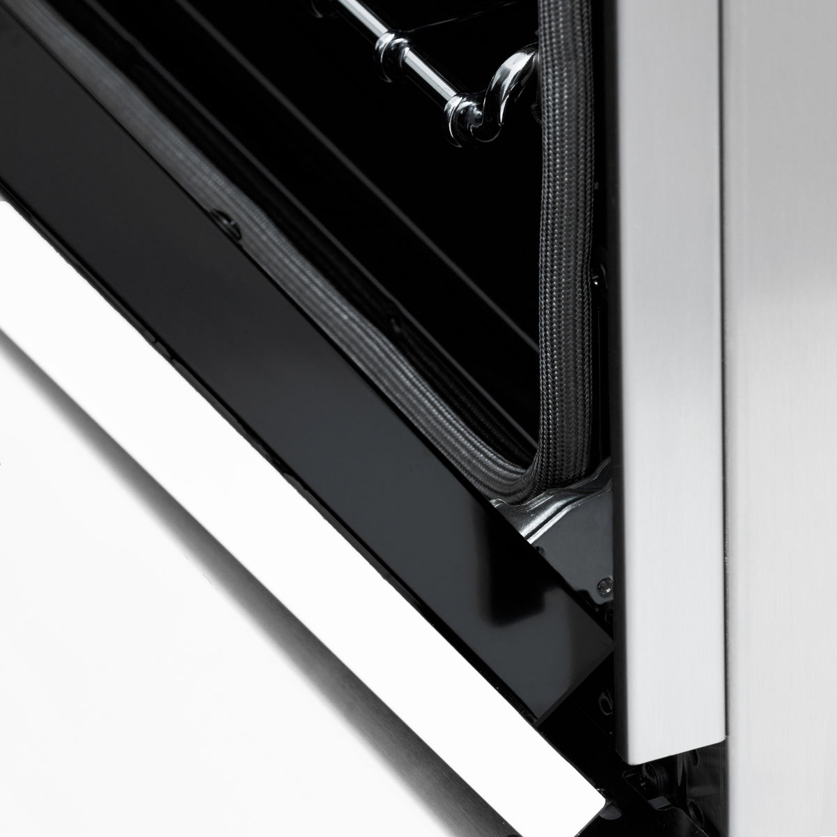 Dual fuel range open door edge with black inner panel and white matte frame