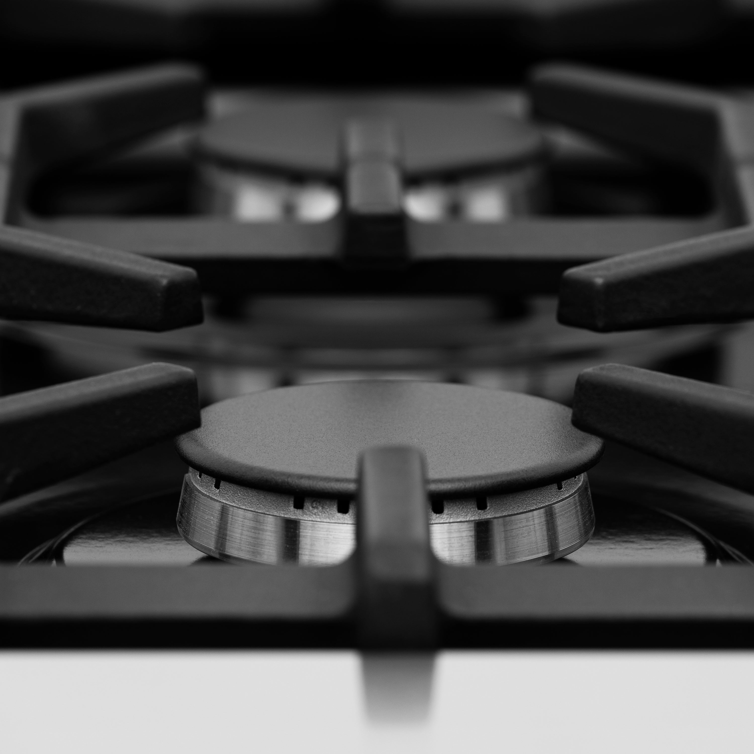 Gas burner with circular burner cap and black grate supports