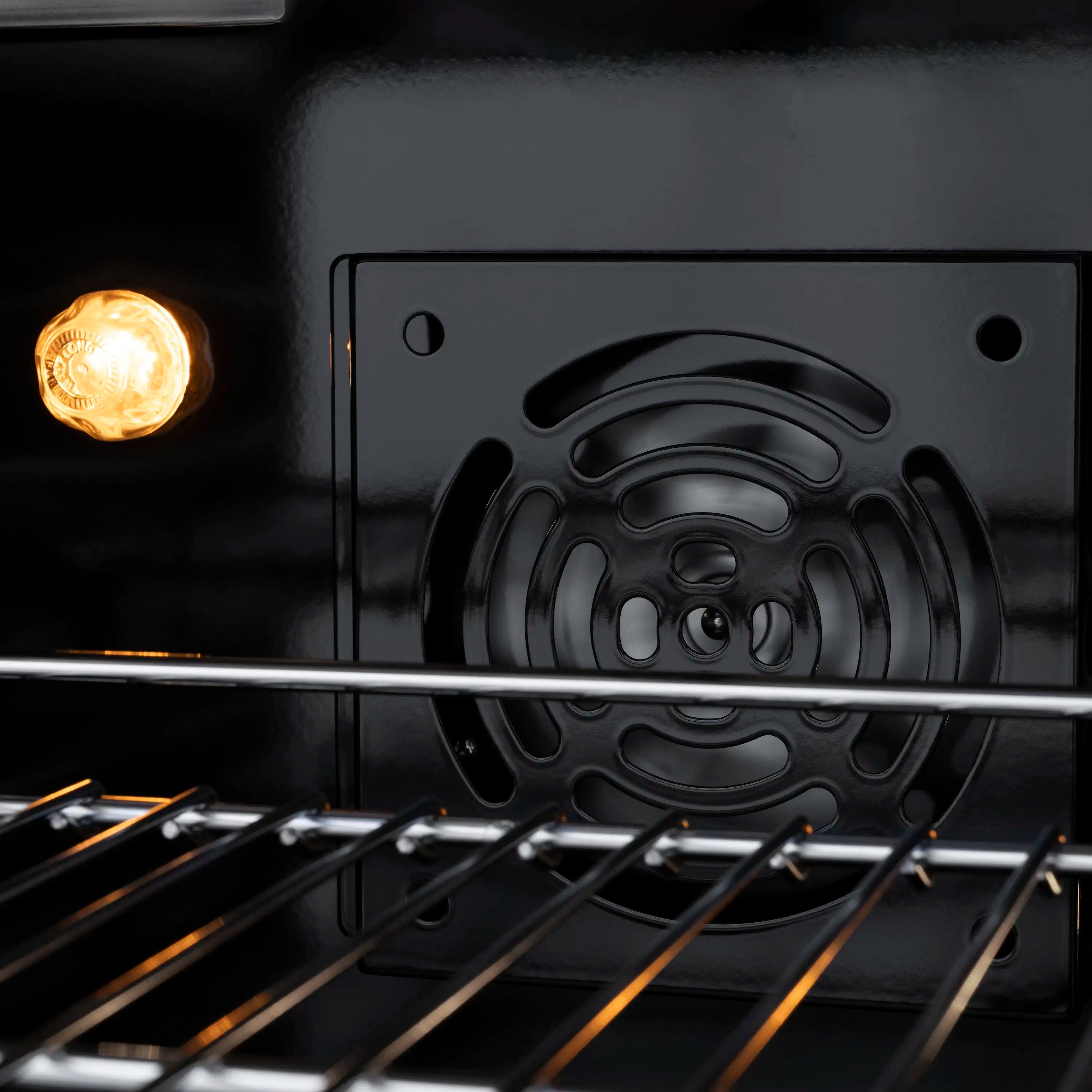 ZLINE oven interior with oven light glowing and dark baking rack