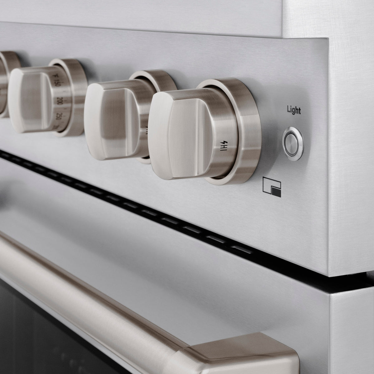 Stainless steel gas range control panel with brass-toned knobs and “Light” button