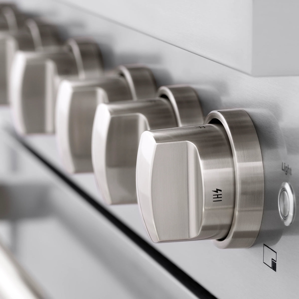 Stainless steel control knobs on a gas range front panel