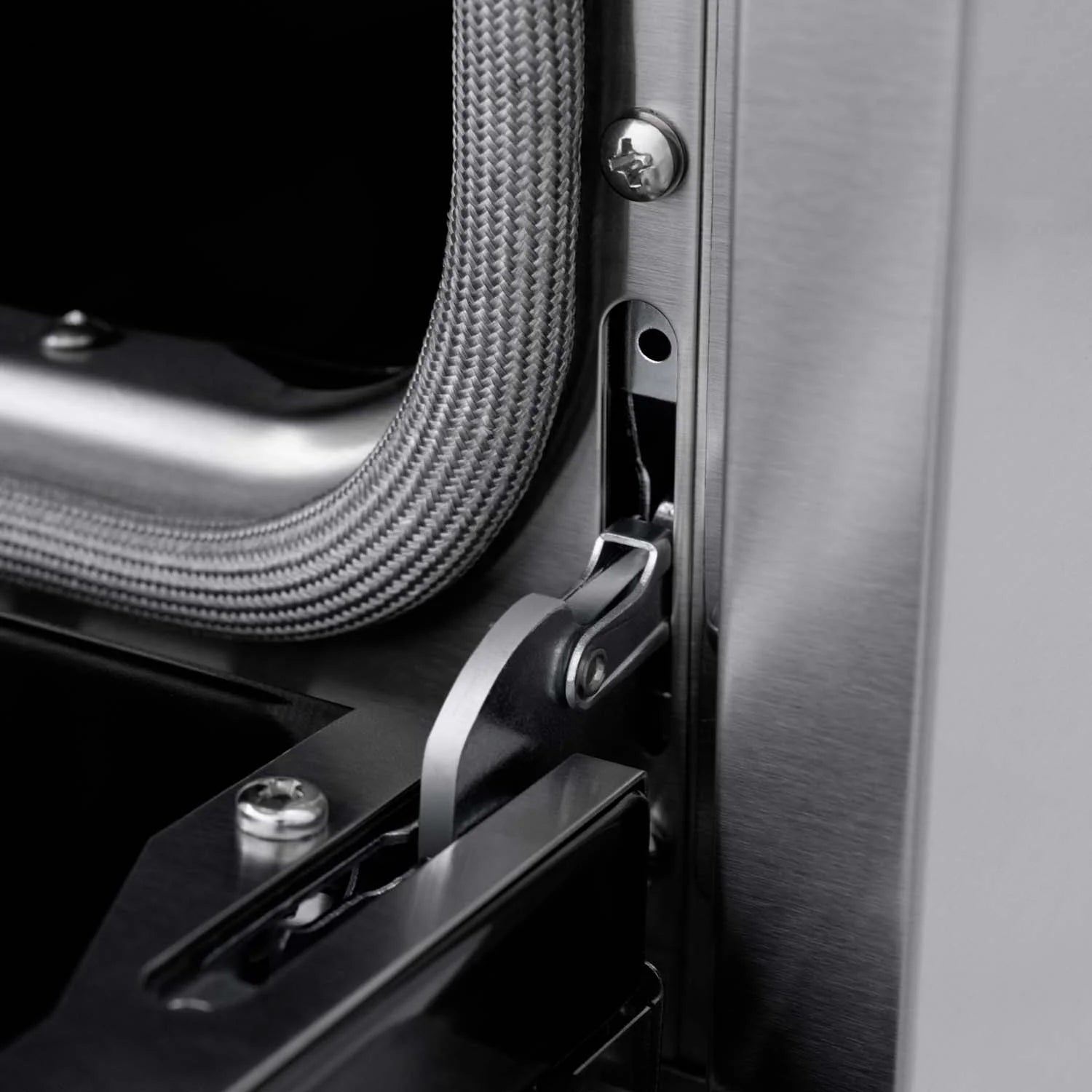 Oven door hinge area with braided gas line and metal latch