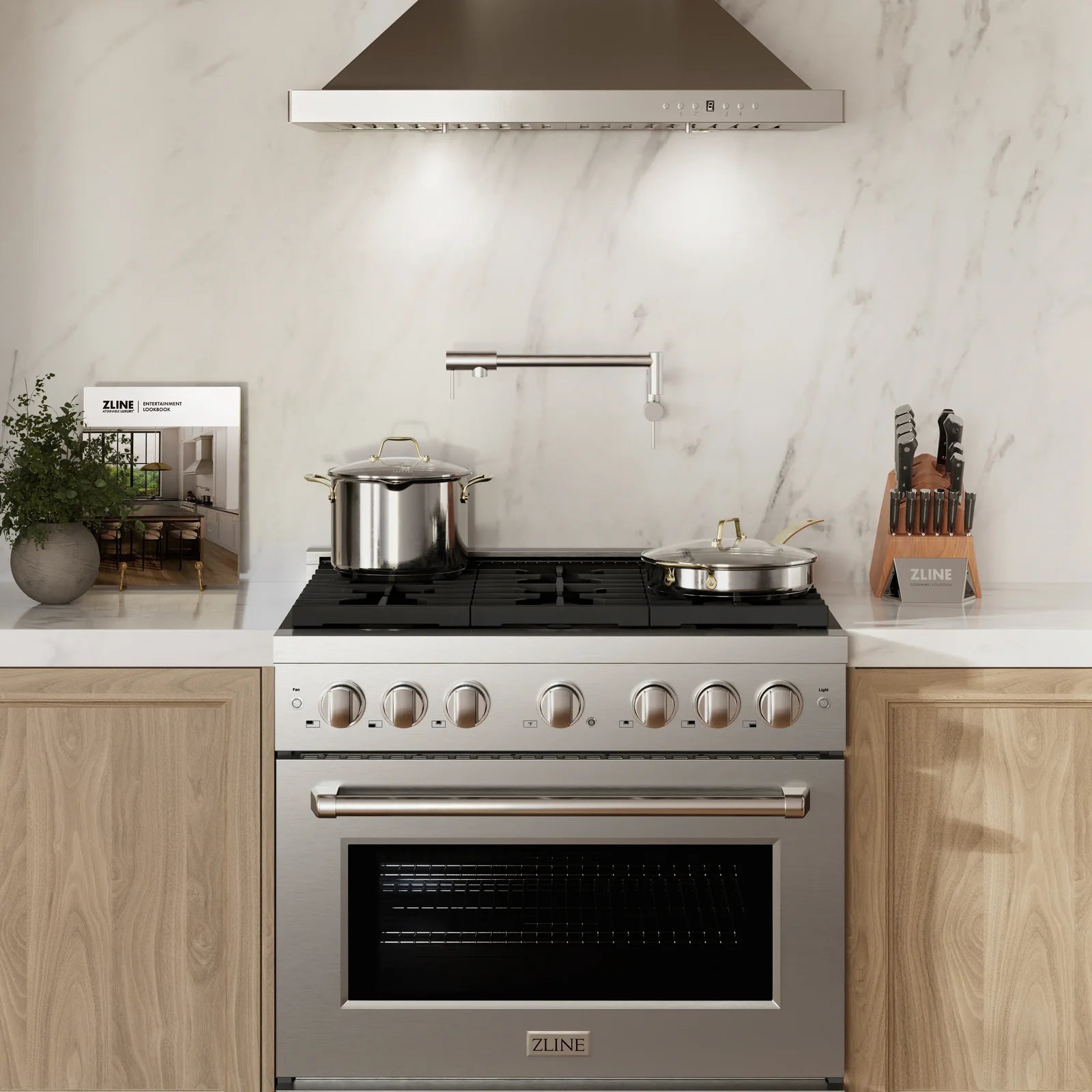 Stainless steel gas range with overhead hood, oven door, and countertop cookware
