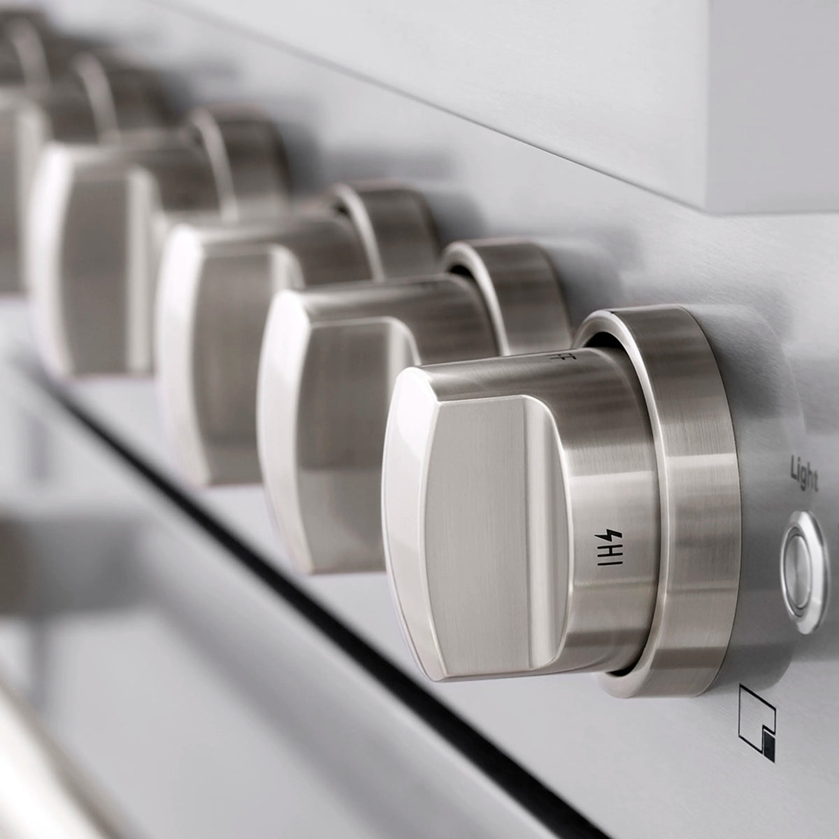 Stainless steel oven control knobs on the gas range front panel