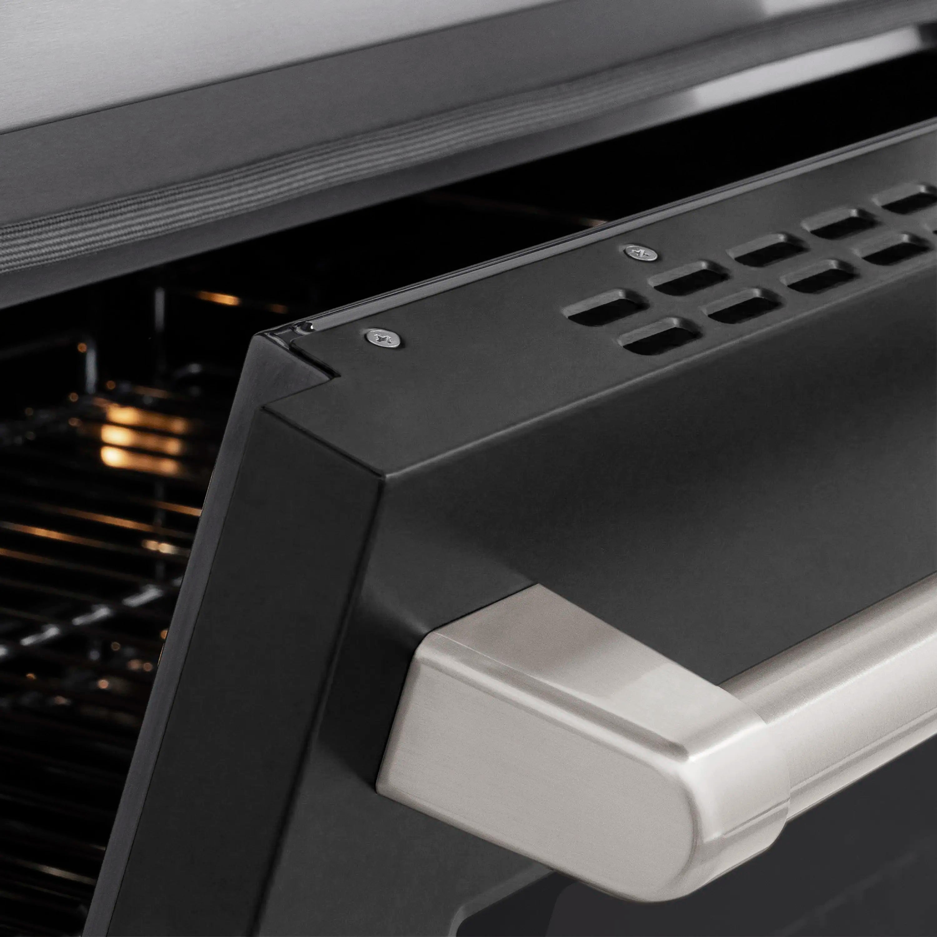 Stainless induction range door with black matte finish and built-in handle.