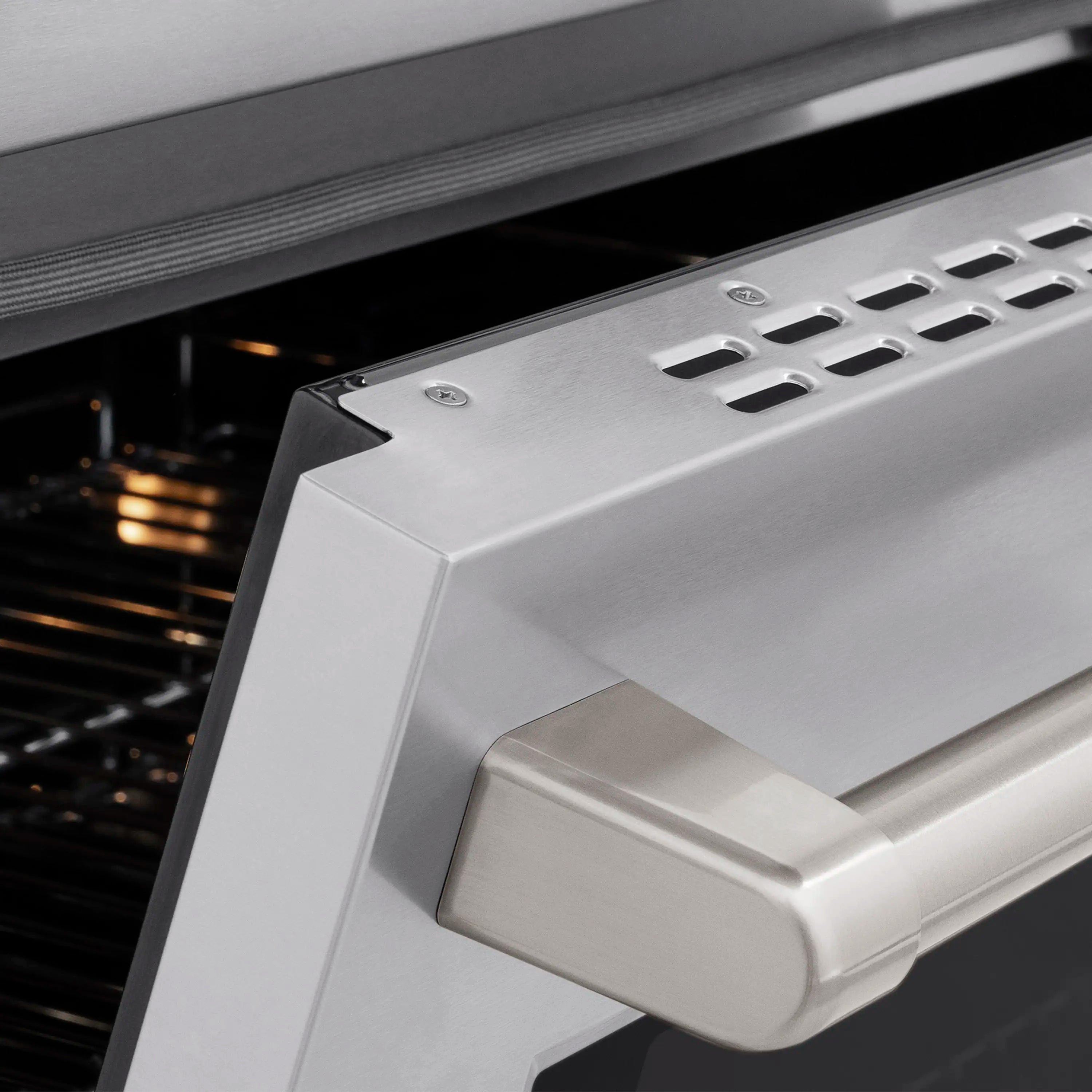 Oven door handle and vent panel on stainless steel induction range