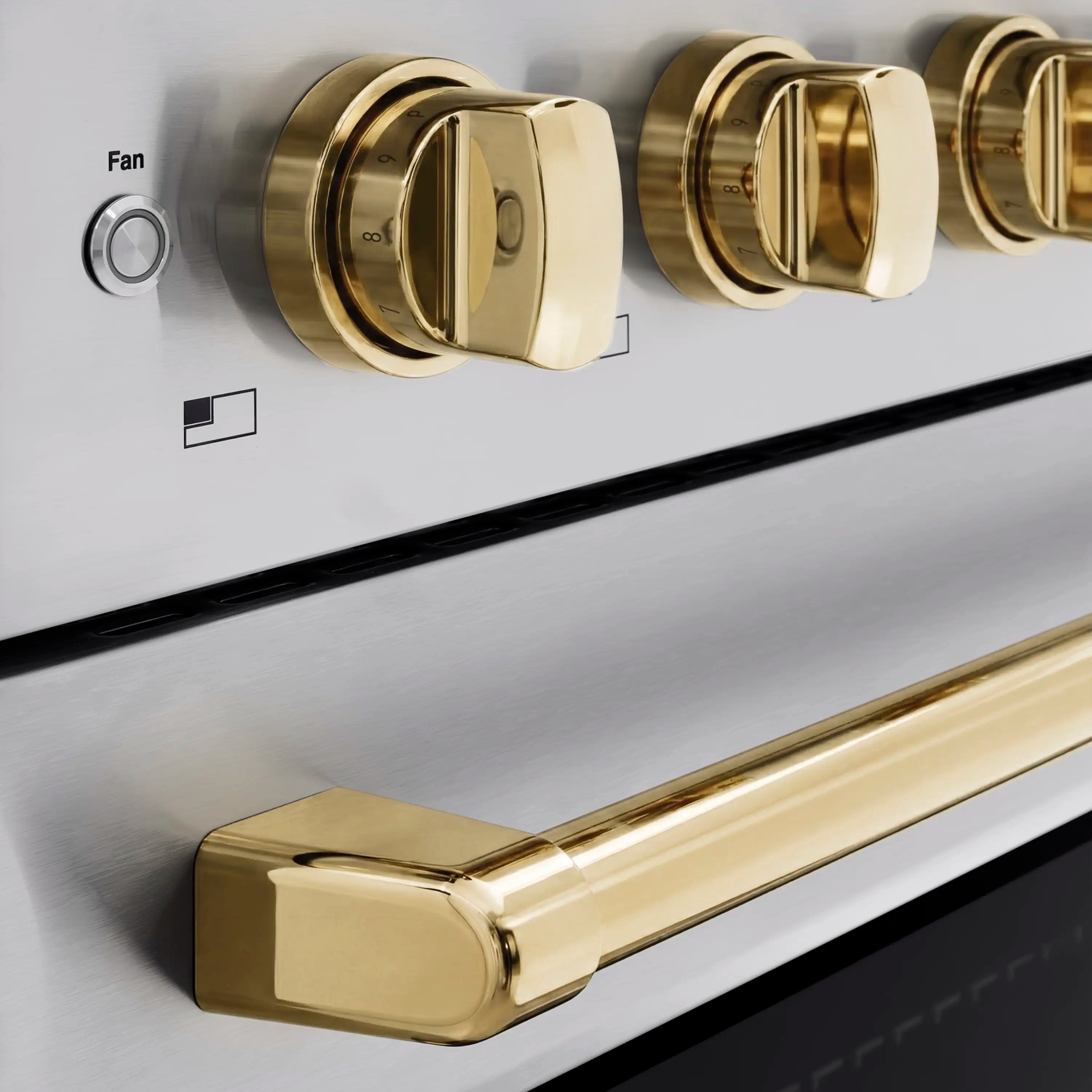 Stainless control panel with round gold knobs and a long gold oven handle