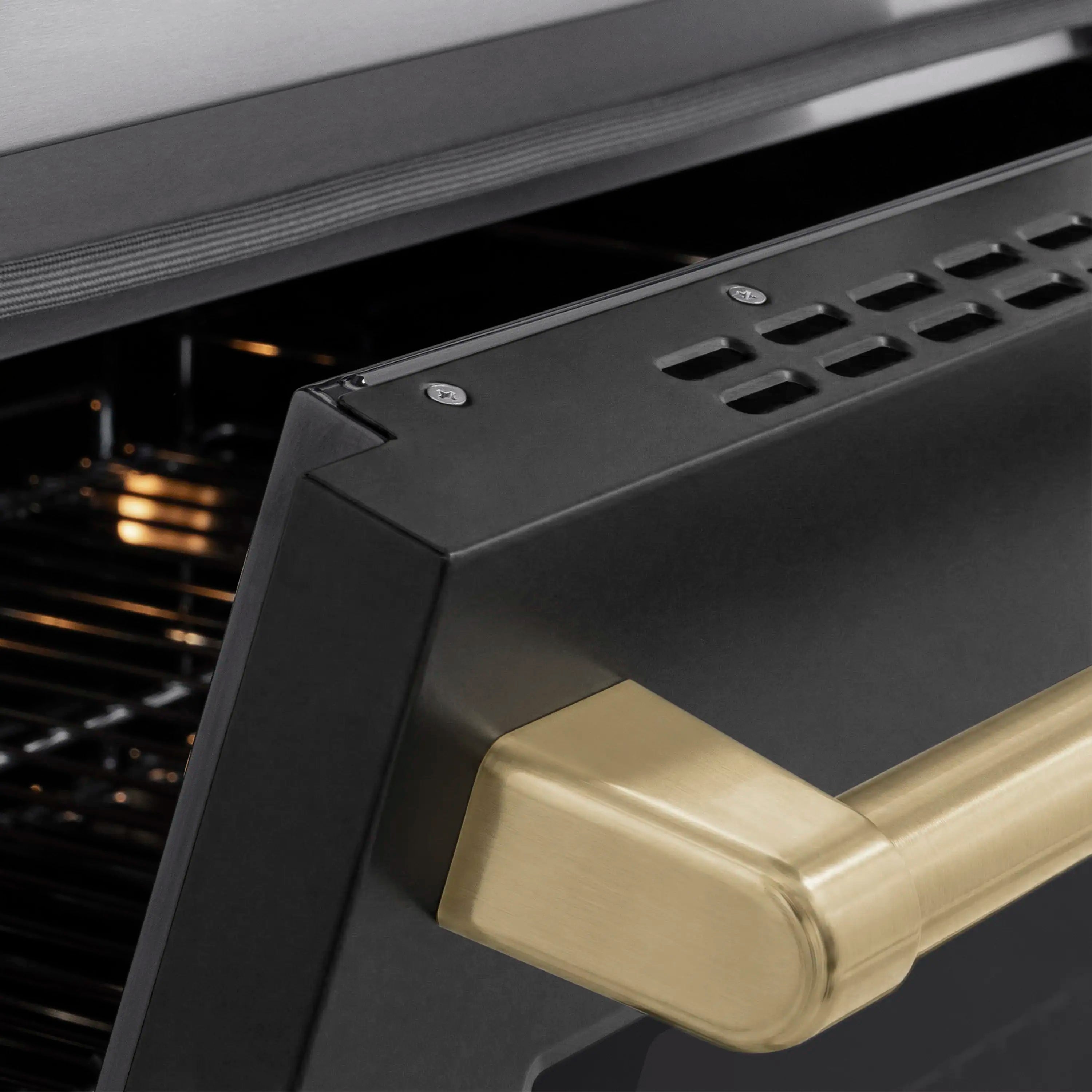 Matte black oven door handle with champagne bronze accent on stainless range
