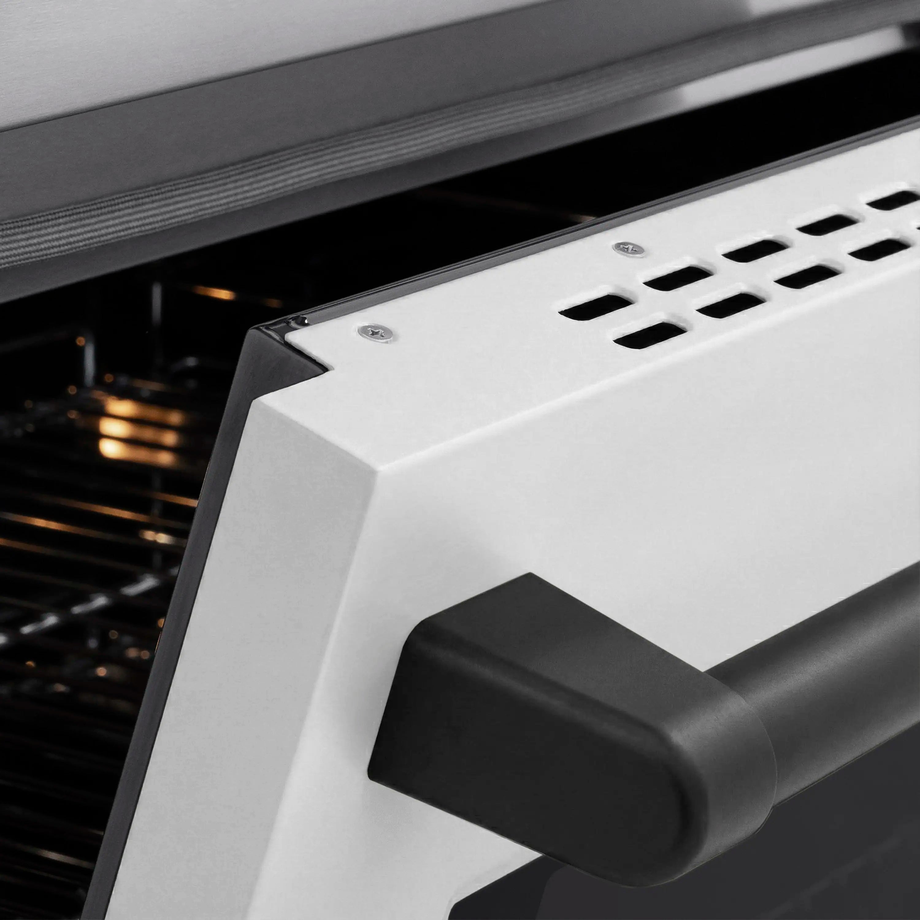 Matte black oven door handle on a white induction range
