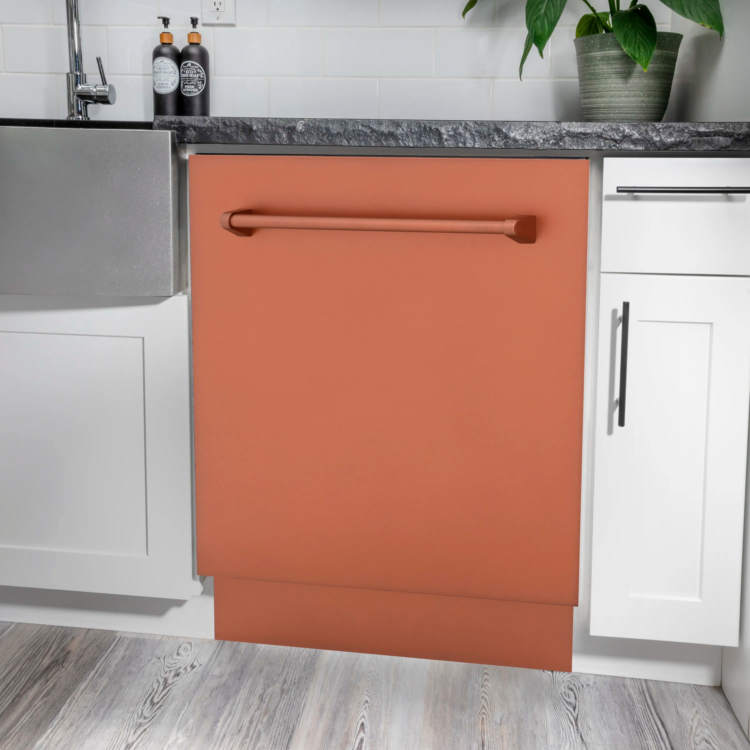 Built-in copper dishwasher installed under countertop with dark stone trim