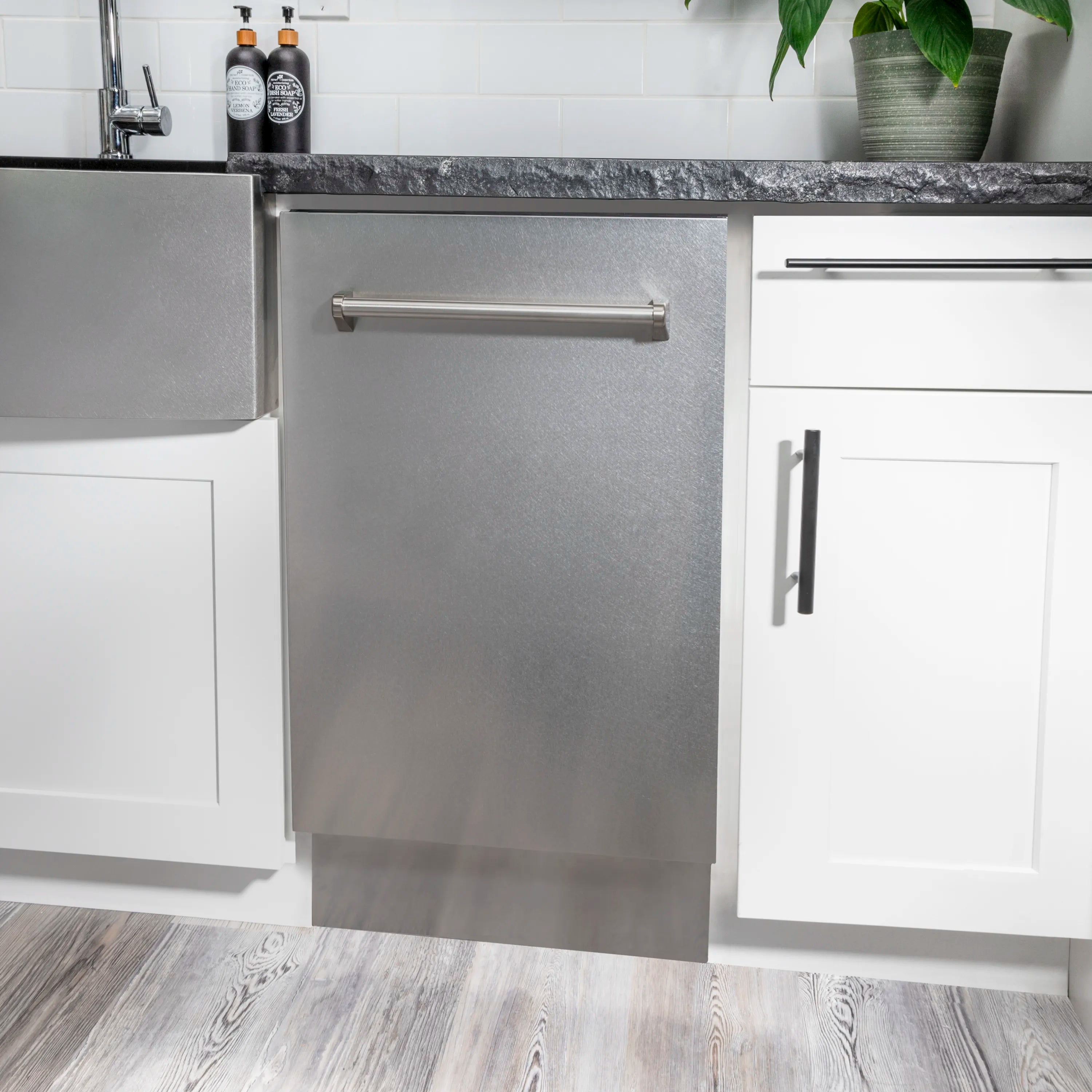 Satin stainless steel dishwasher installed under countertop with front handle