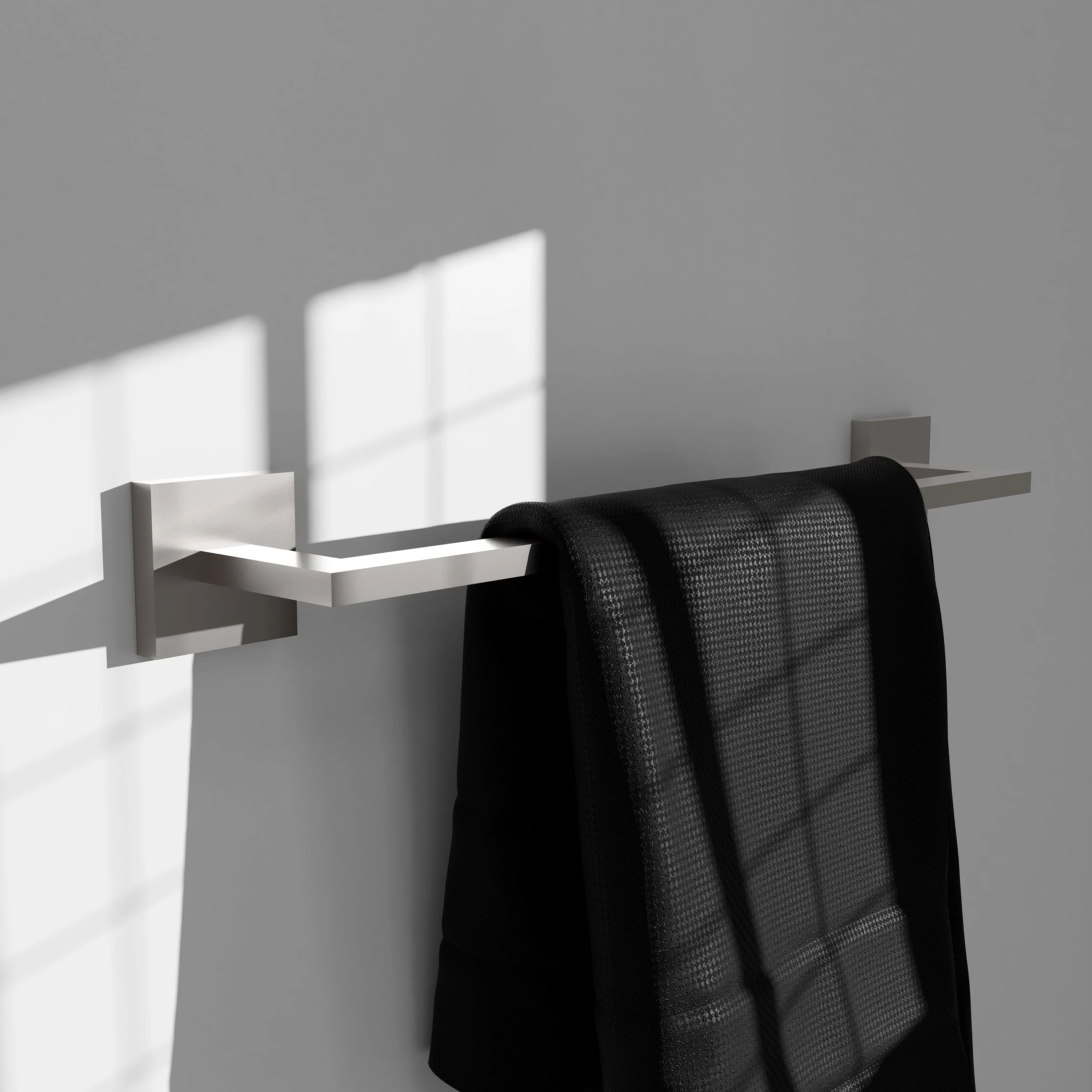 Brushed nickel towel rail holding a folded black towel, with square end mounting brackets.