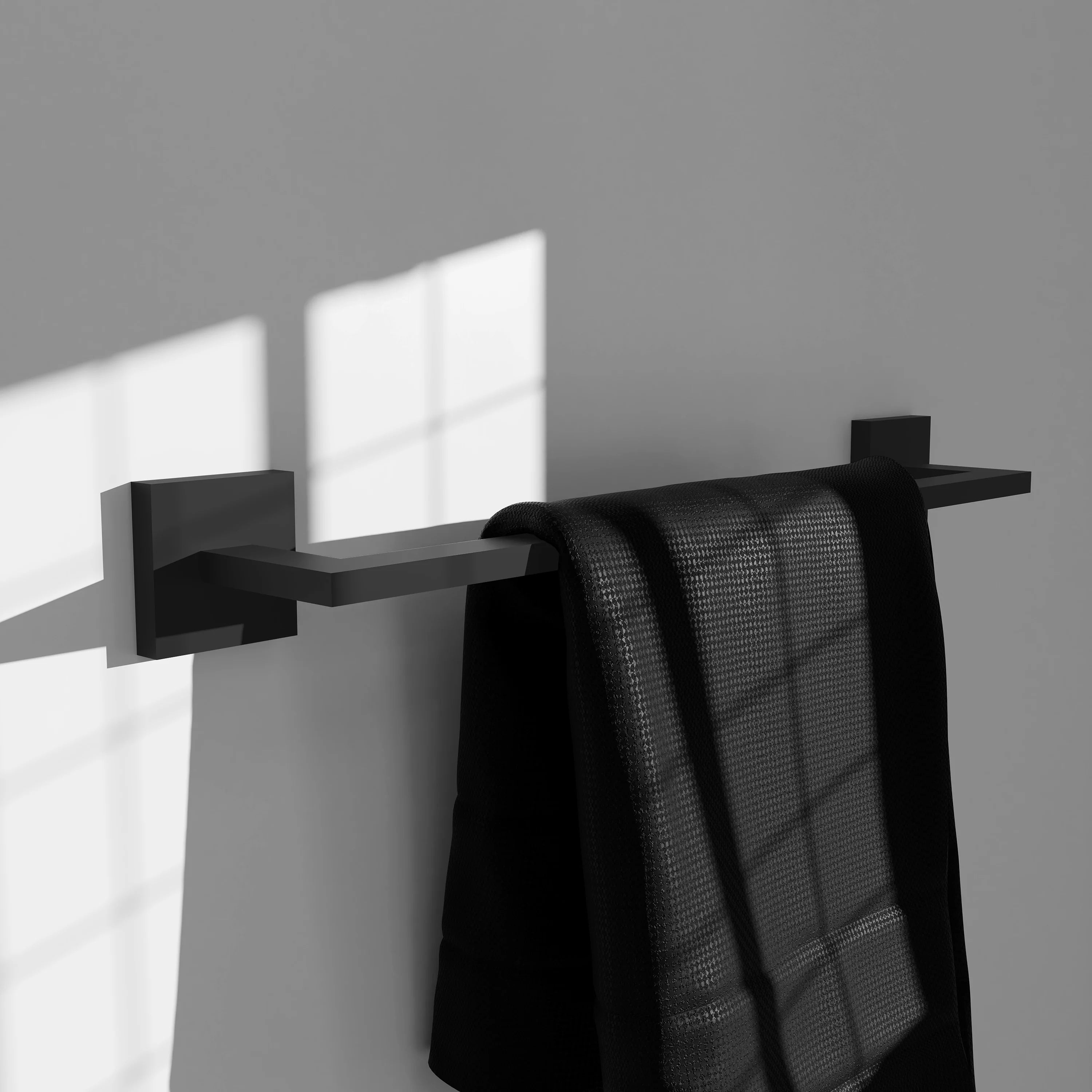 Matte black towel rail holding two folded towels on the bar with square mounts.