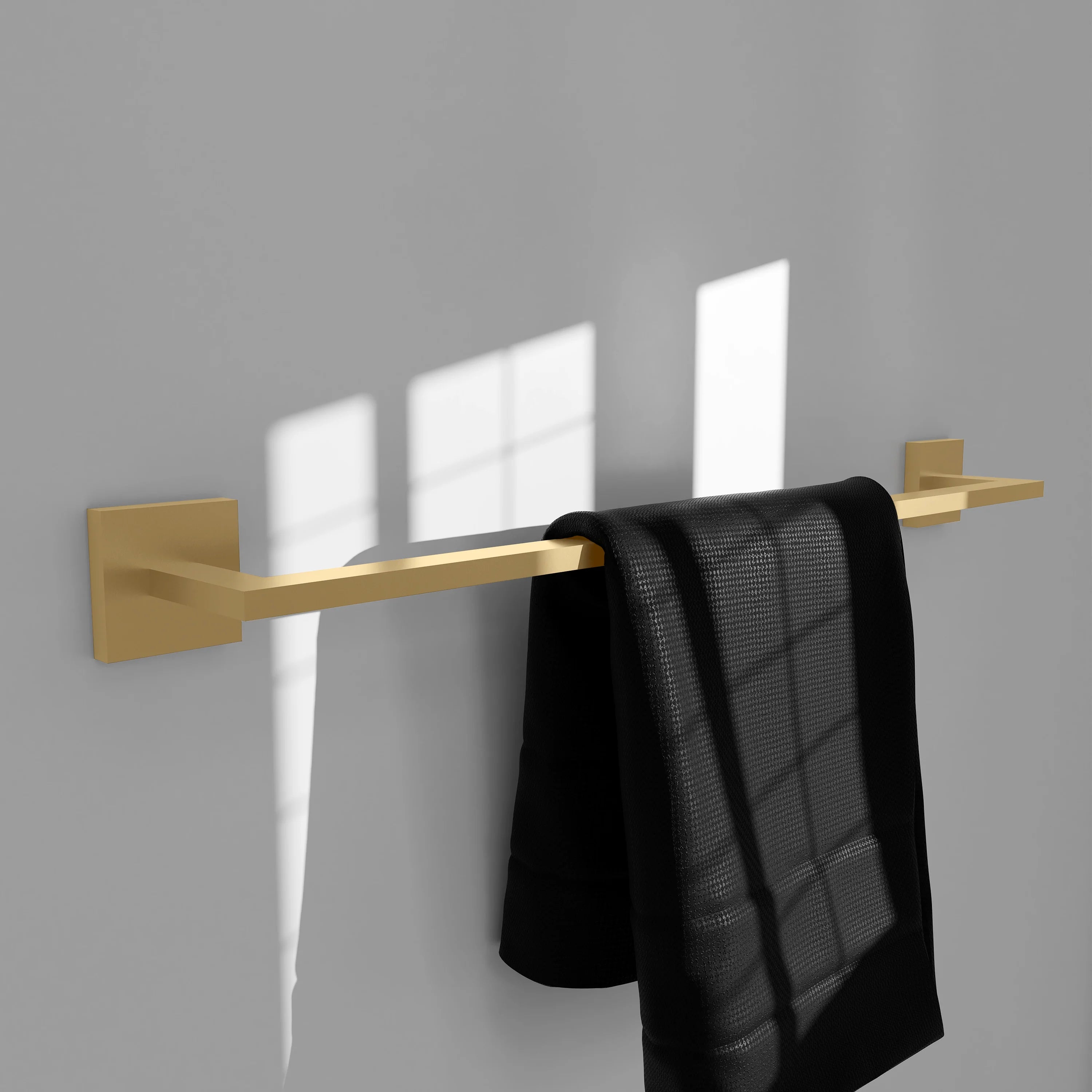 Champagne bronze towel rail with folded black towels hanging from the bar