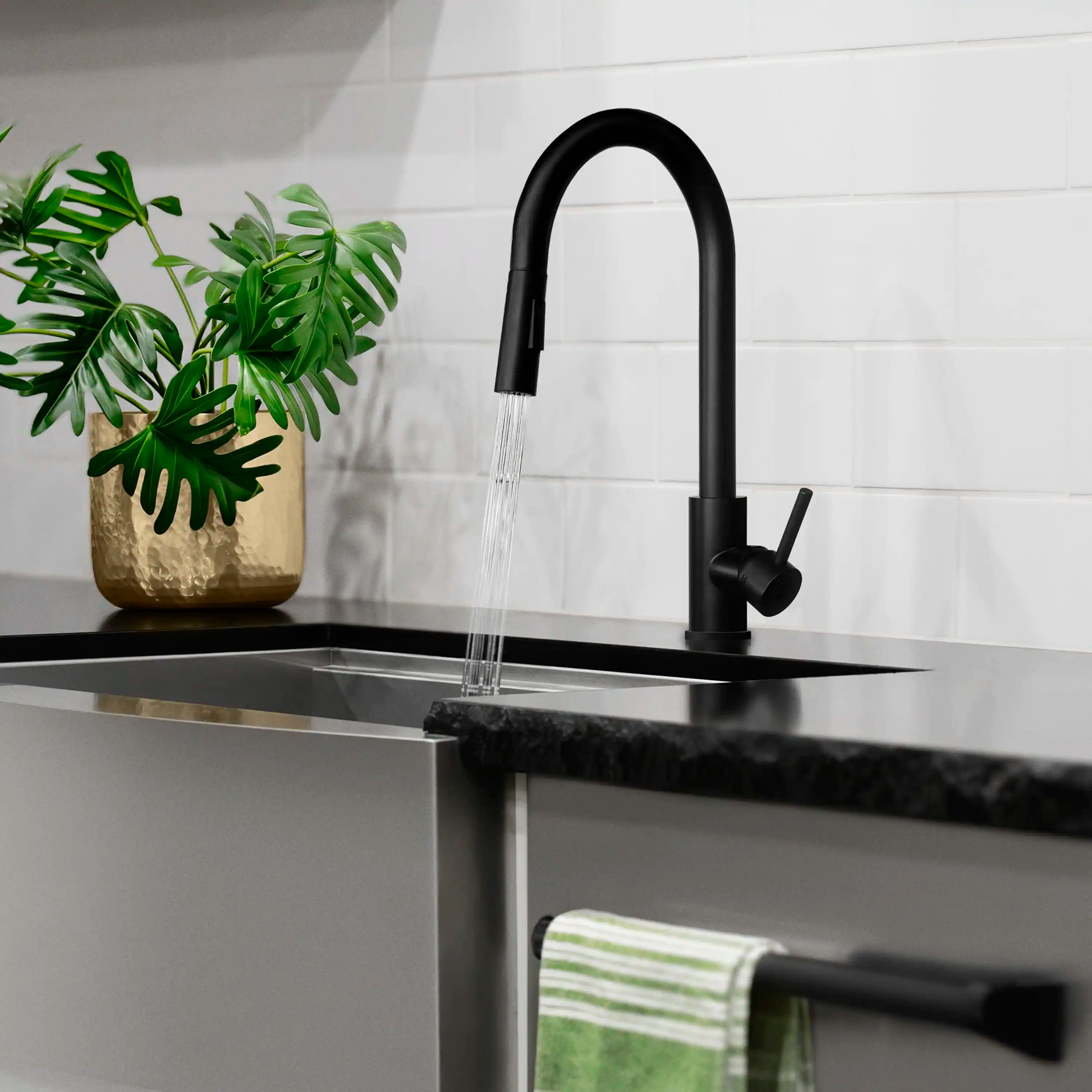 Matte black kitchen faucet with pull-down sprayer head spraying water