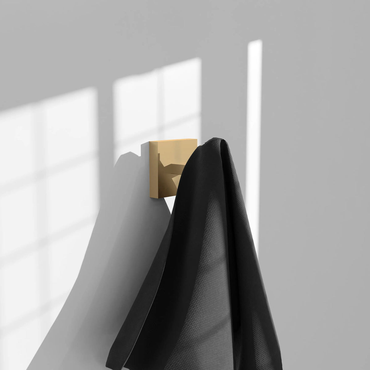 Champagne bronze towel hook holding a folded black towel