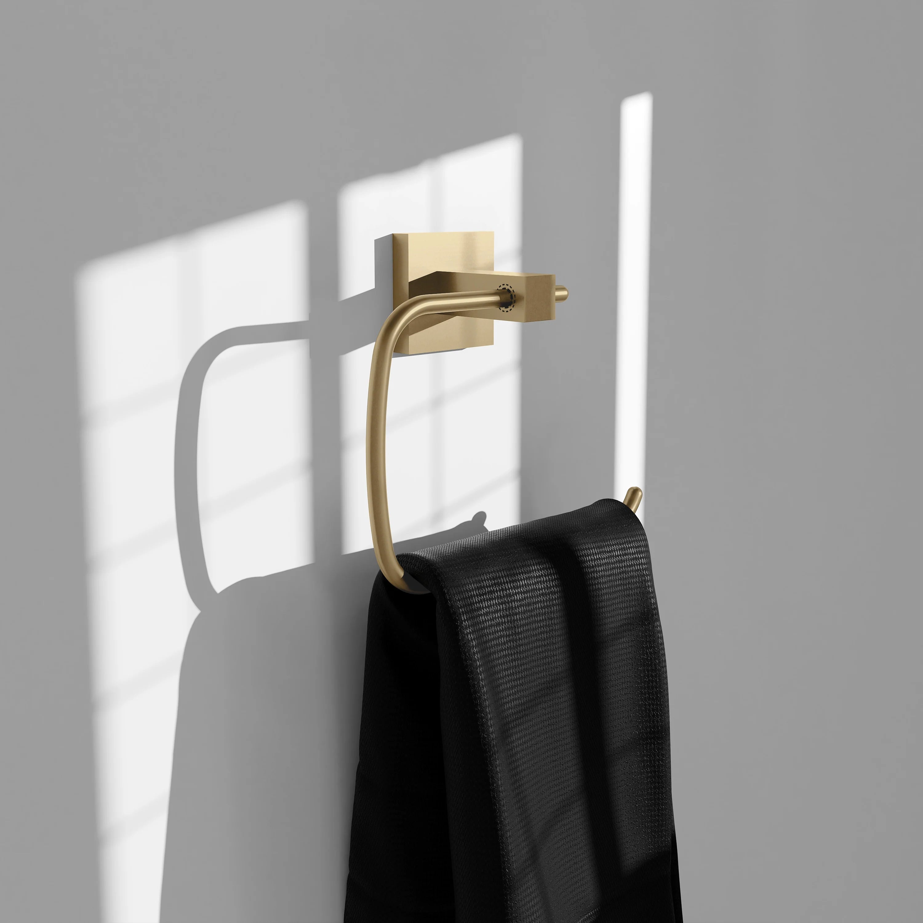 Champagne bronze towel ring holding two folded black towels