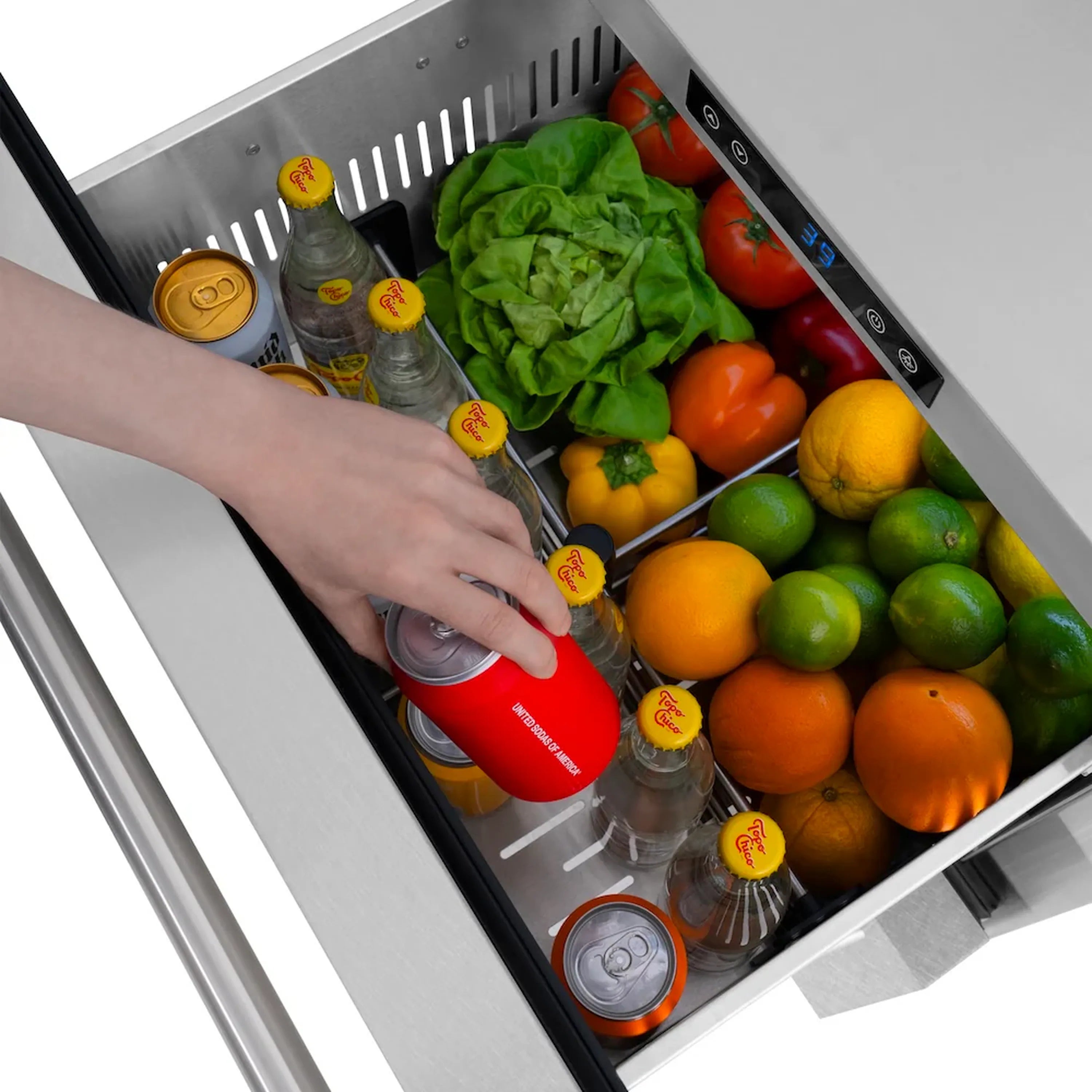 Refrigerator drawer interior with hand placing beverage can among fruits and leafy greens