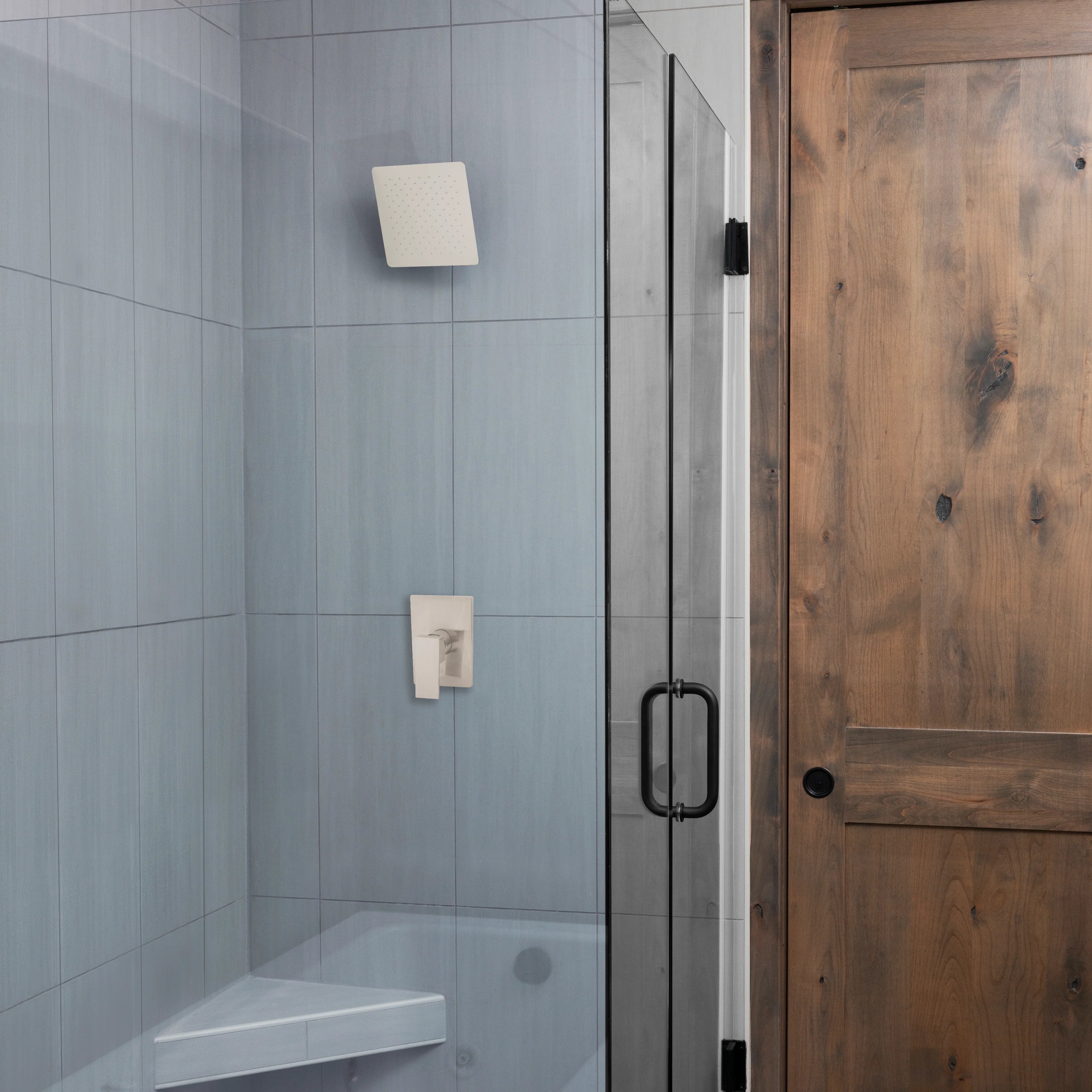 Brushed nickel square shower head mounted on shower wall