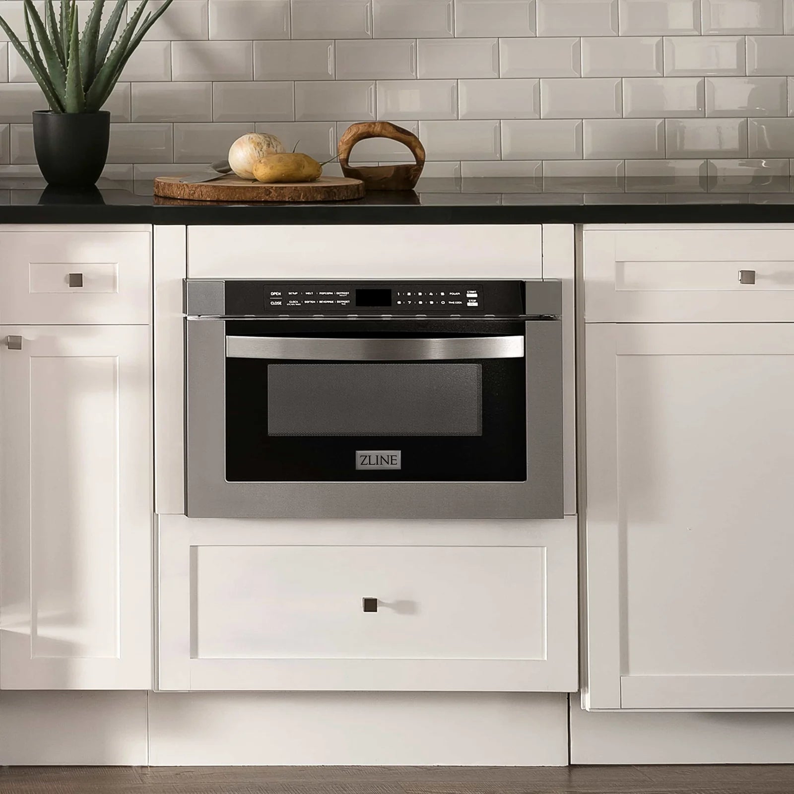 Built-in stainless steel microwave drawer installed in a kitchen cabinet