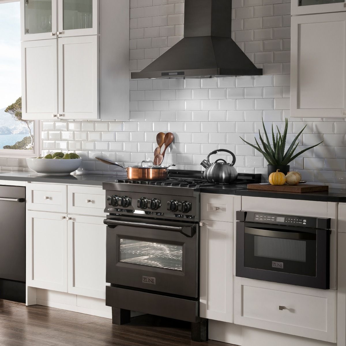 Black dual-fuel range in a kitchen with a front oven window and cooktop burners