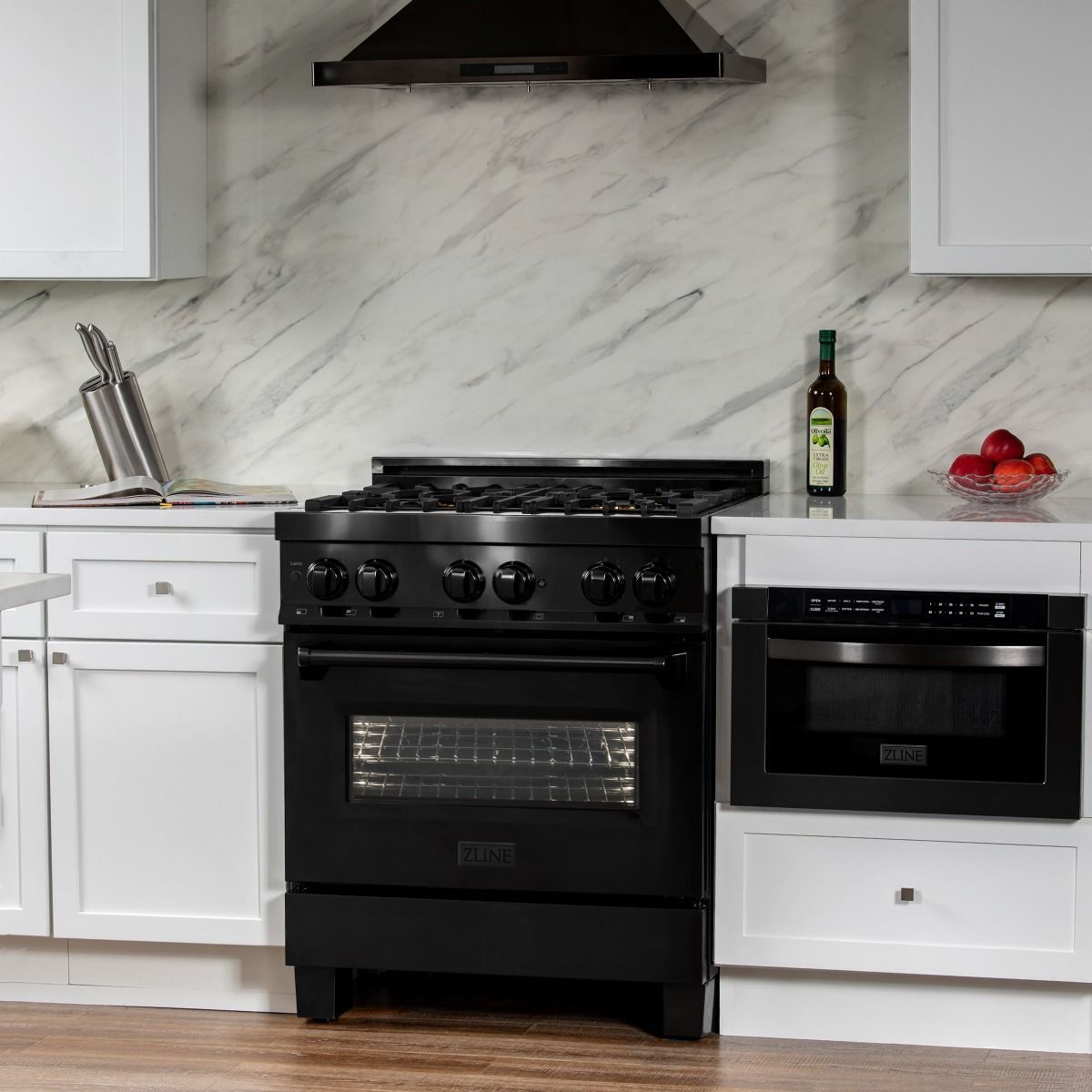 Black dual-fuel range cooktop and oven door beneath a stainless range hood