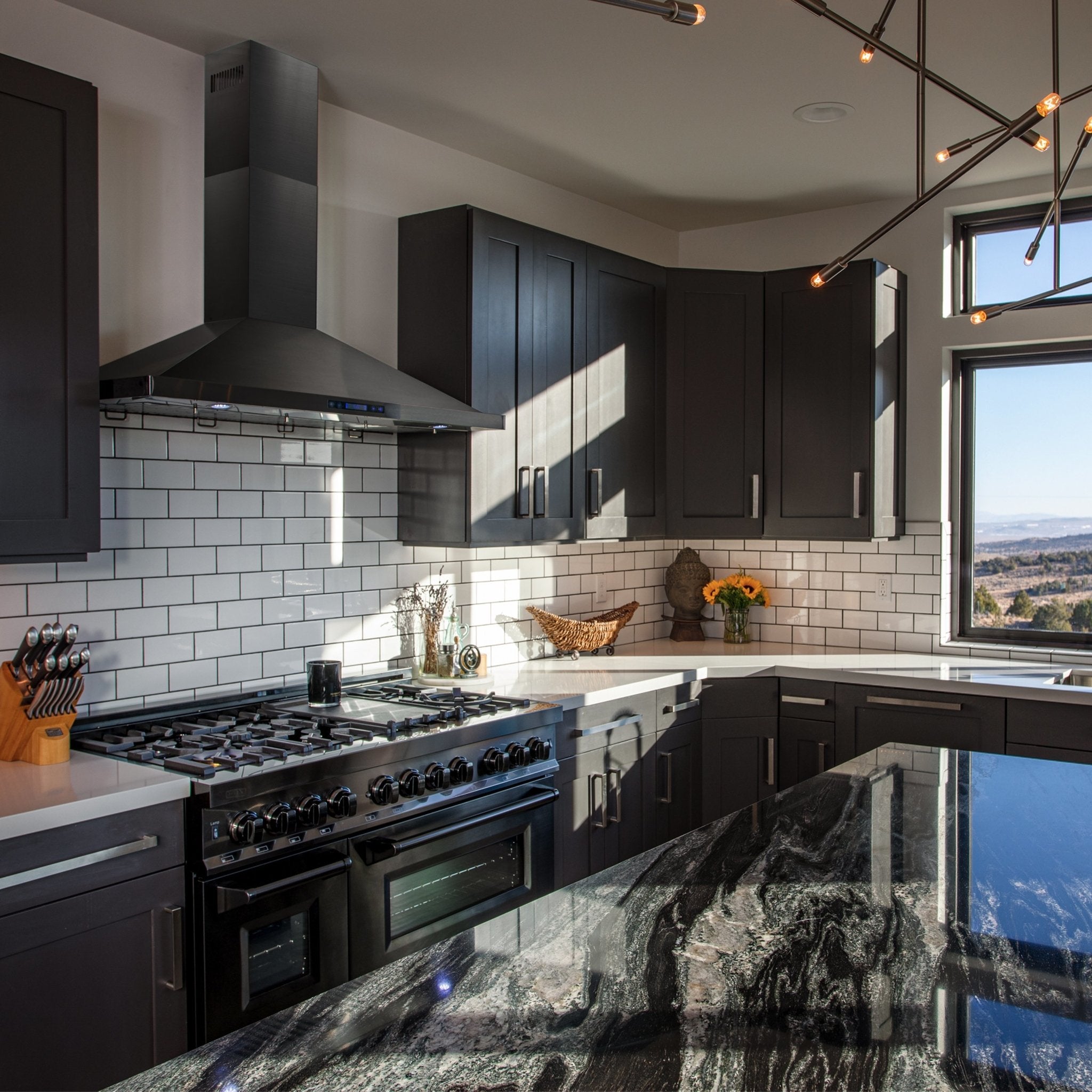 Black stainless steel convertible wall mount range hood above a cooktop in a kitchen
