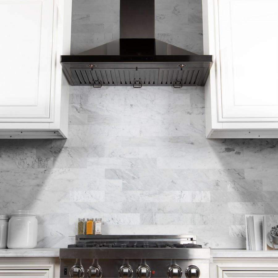 Black stainless steel range hood with chimney and vent filters centered over cooktop