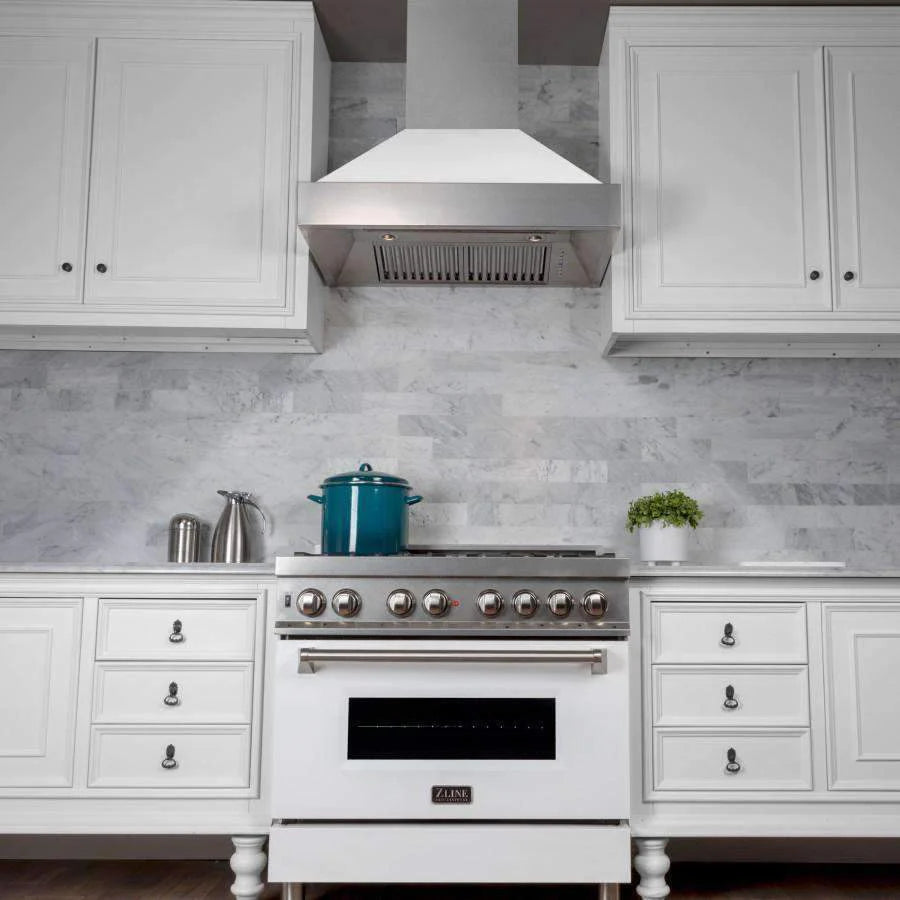 White dual fuel range with satin stainless hood and central burner grates