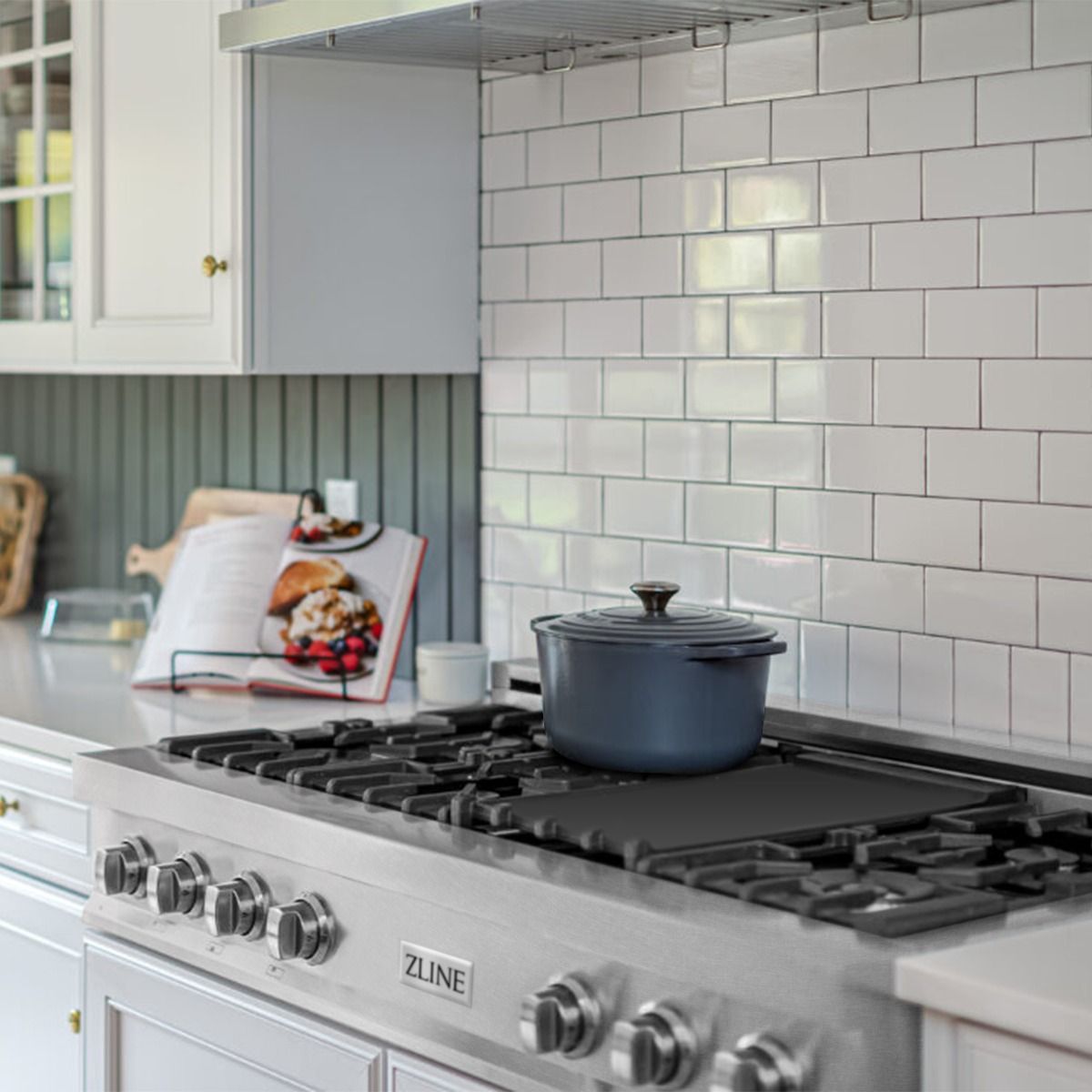 Satin stainless steel gas rangetop with black grates and a covered pot