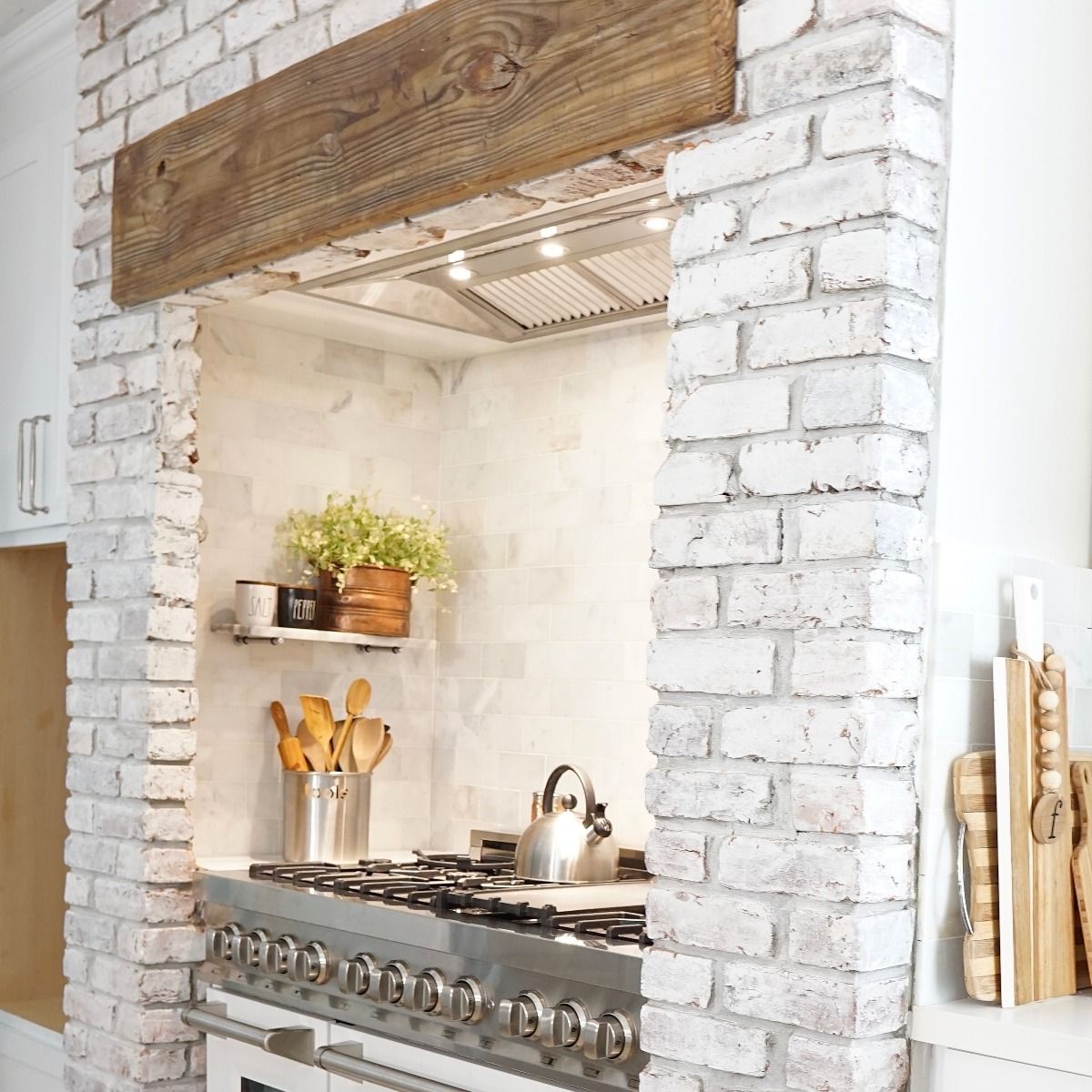 Under-cabinet stainless range hood insert with vent grille above the cooktop