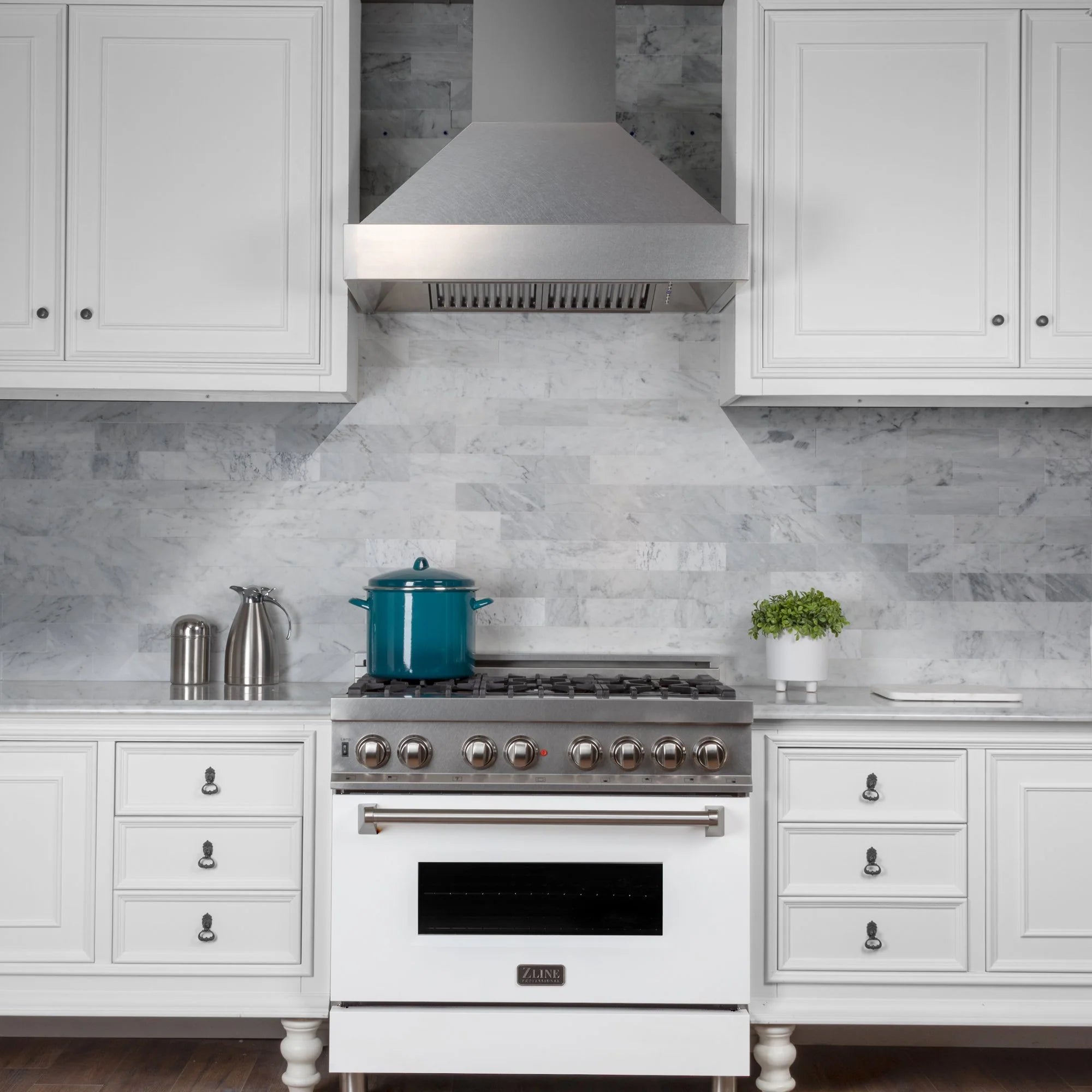 Gas range with stainless wall hood above, multiple burners and central oven door