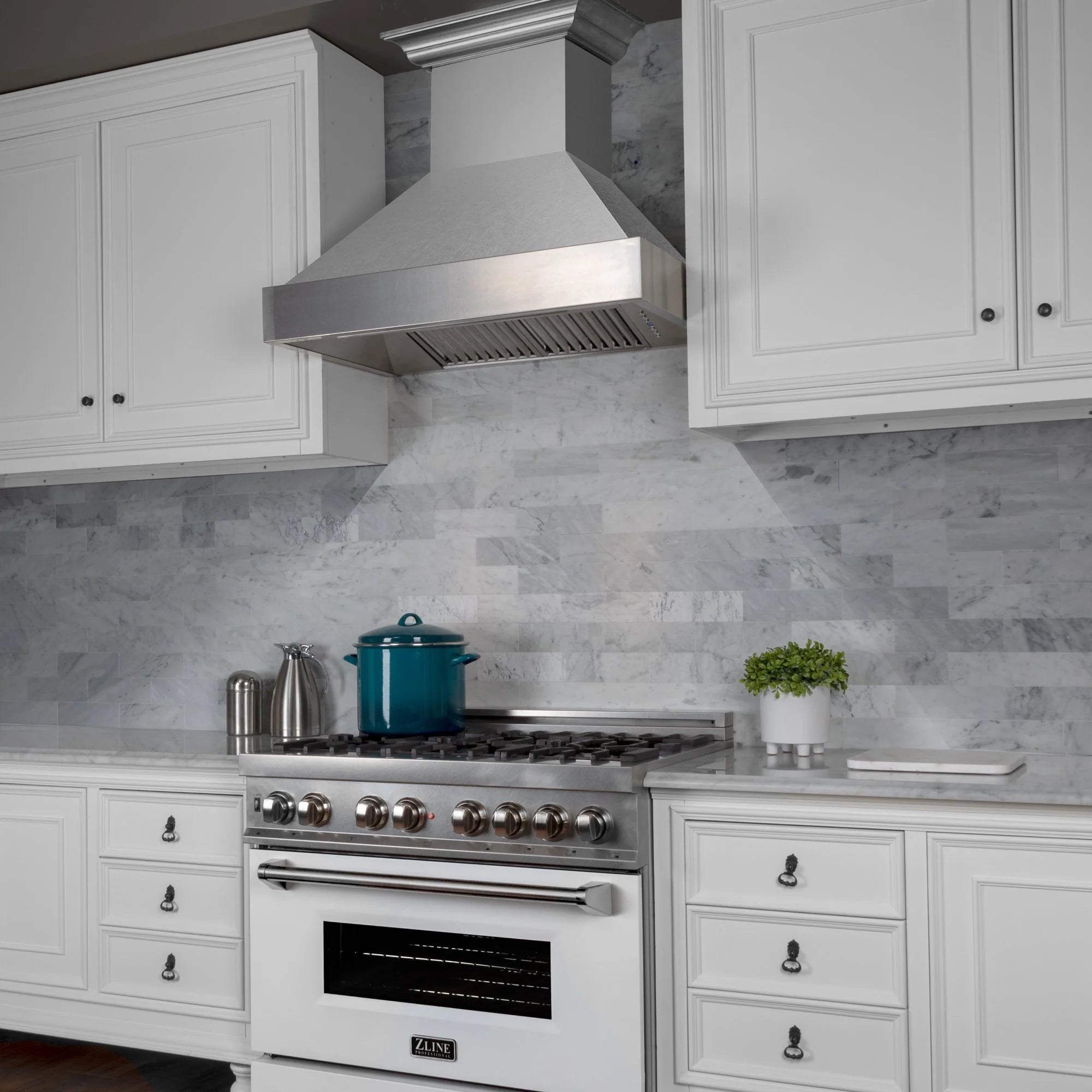 Satin stainless steel wall hood over gas range with multiple burners