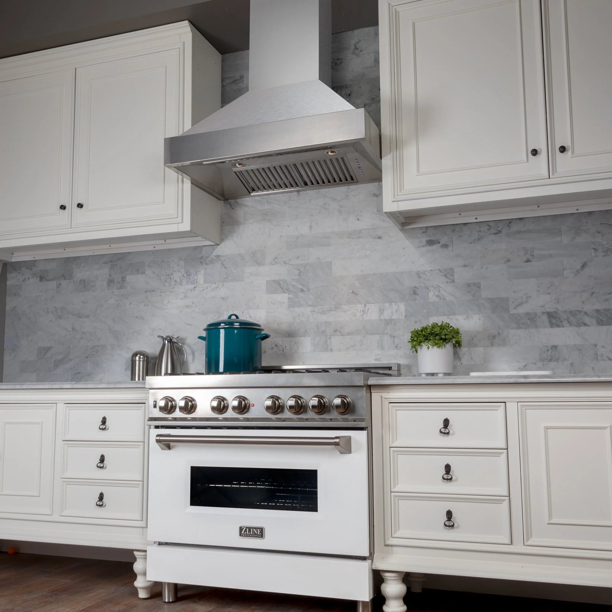 White gas range with satin stainless steel wall hood and front control knobs
