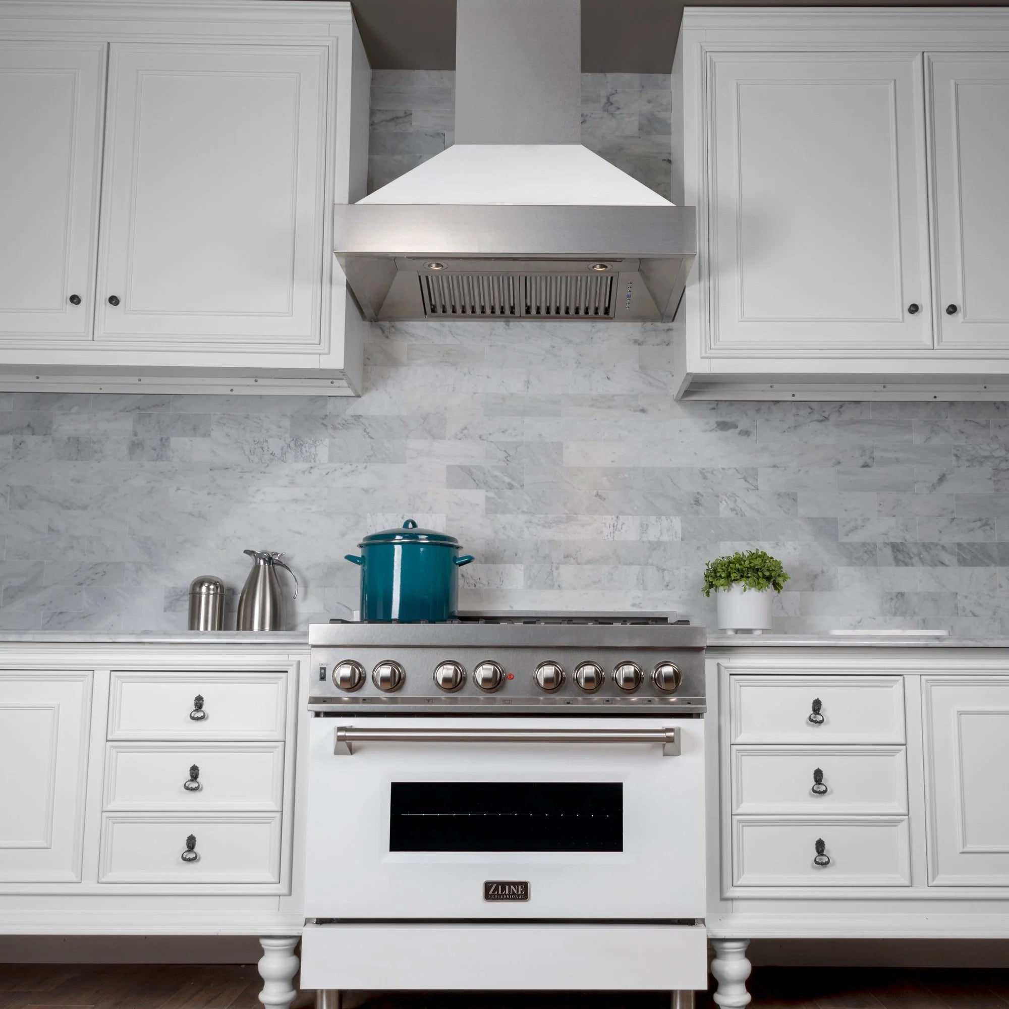 Chimney range hood above white gas range with control knobs and oven door