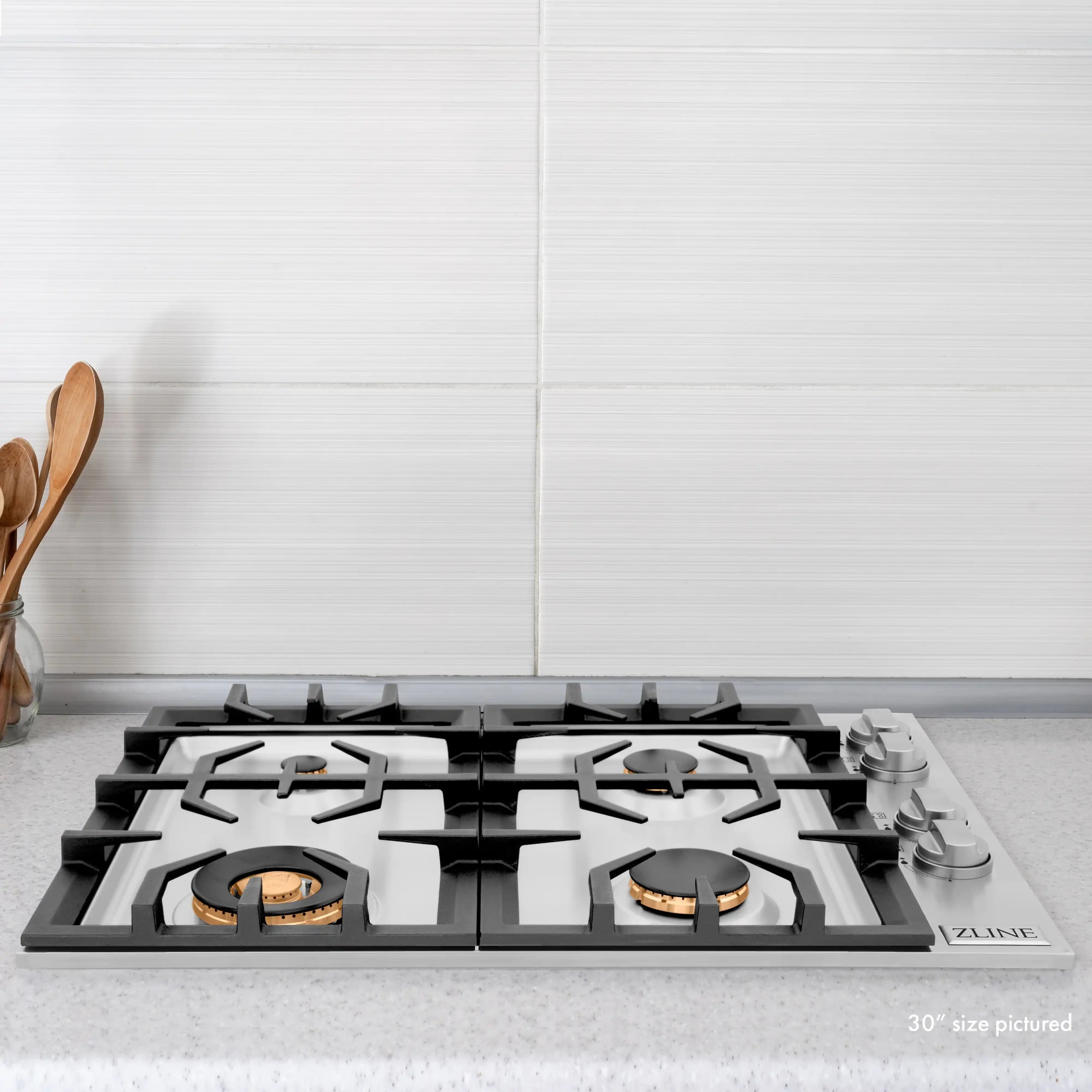 Gas cooktop with six brass-trim gas burners on black grates